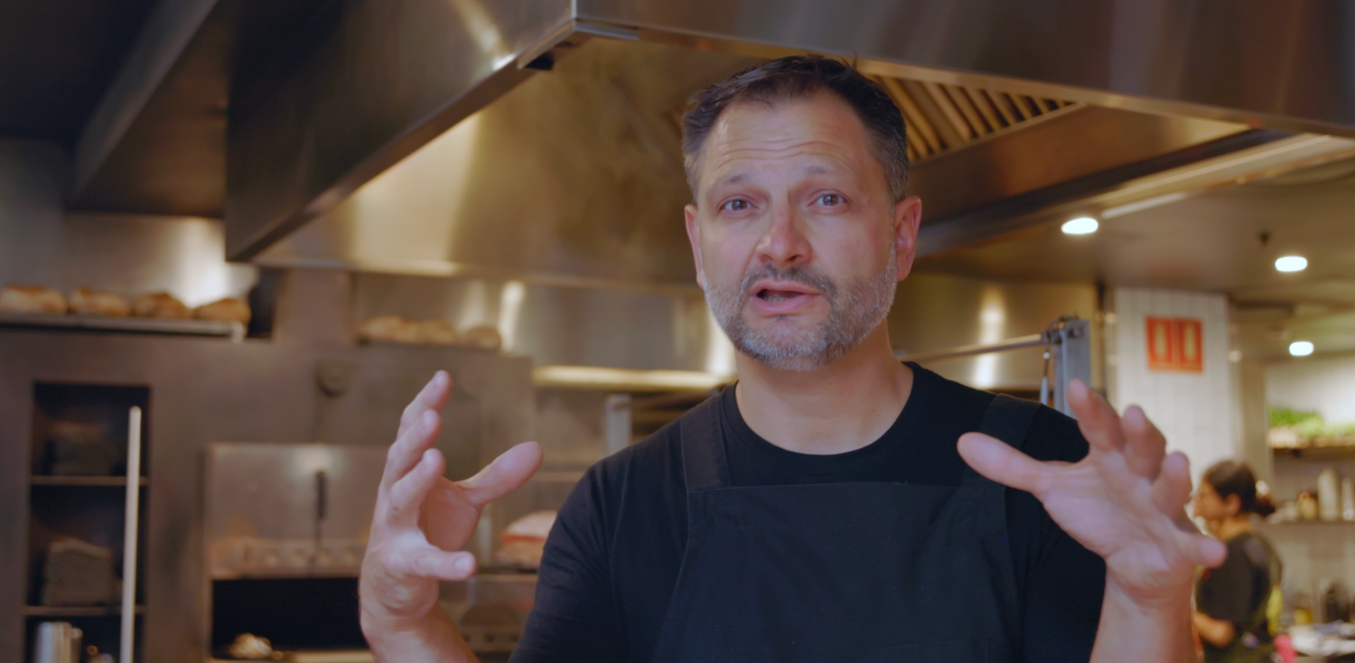 Wollongong based videographer captures professional kitchen with stainless steel appliances and wood-fired grill in operation Firedoor