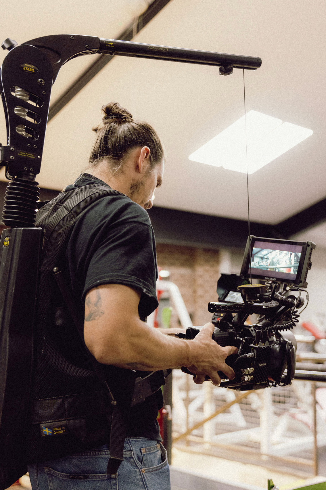 Videographer operating professional camera equipment in an indoor commercial setting. Professional videographer in sydney
