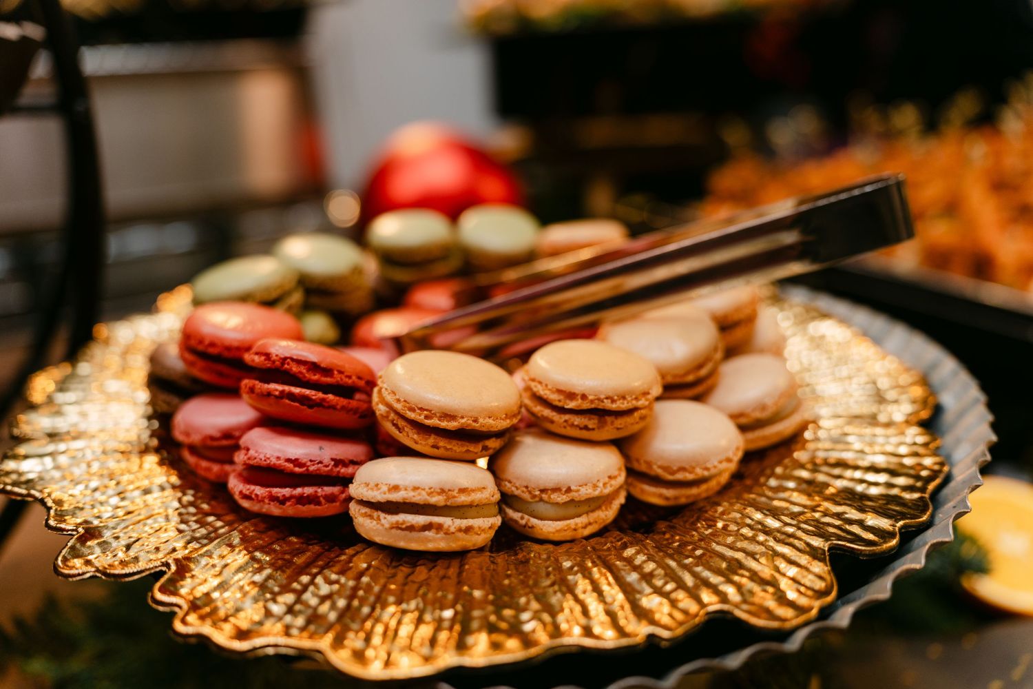 Elegant display of colorful macarons arranged on gold serving platters.