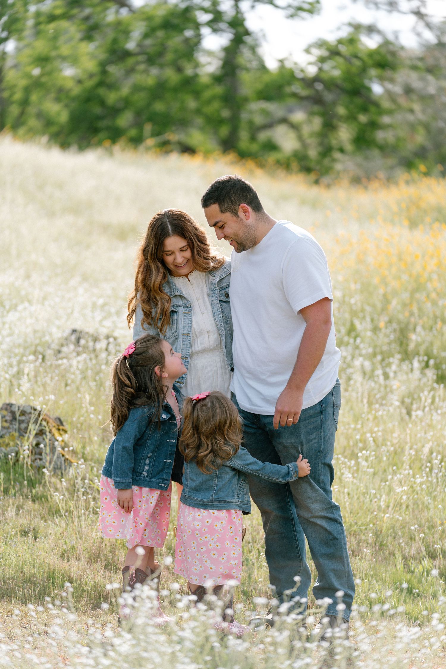 Candid family moment captured in a wildflower field during golden hour.