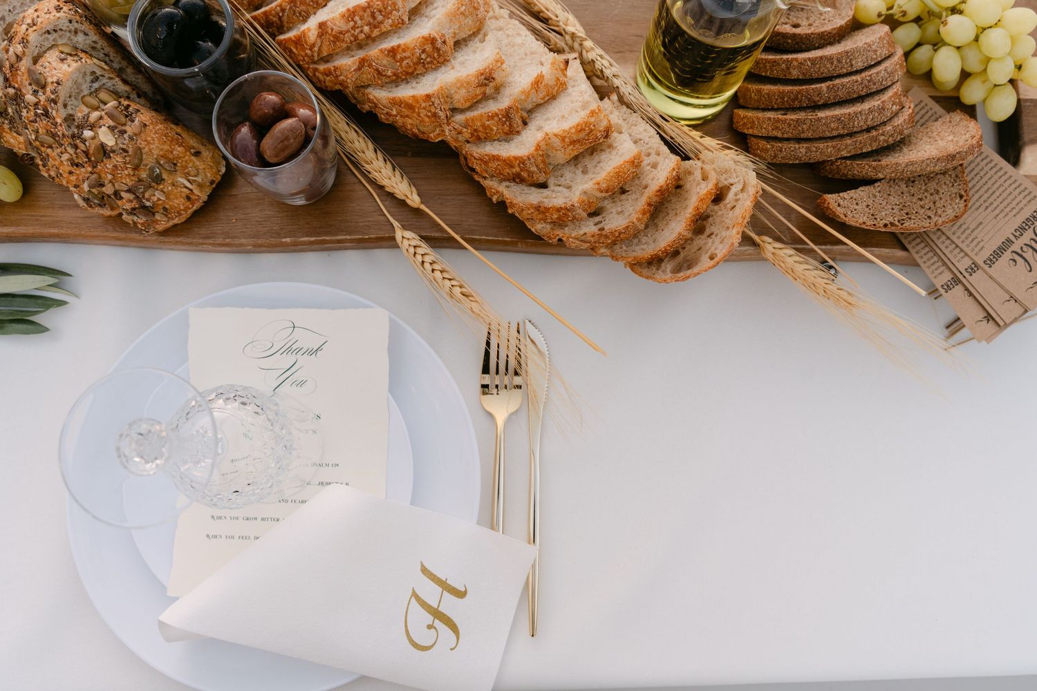Artisanal bread and cheese board display with fresh grapes and elegant place settings.
