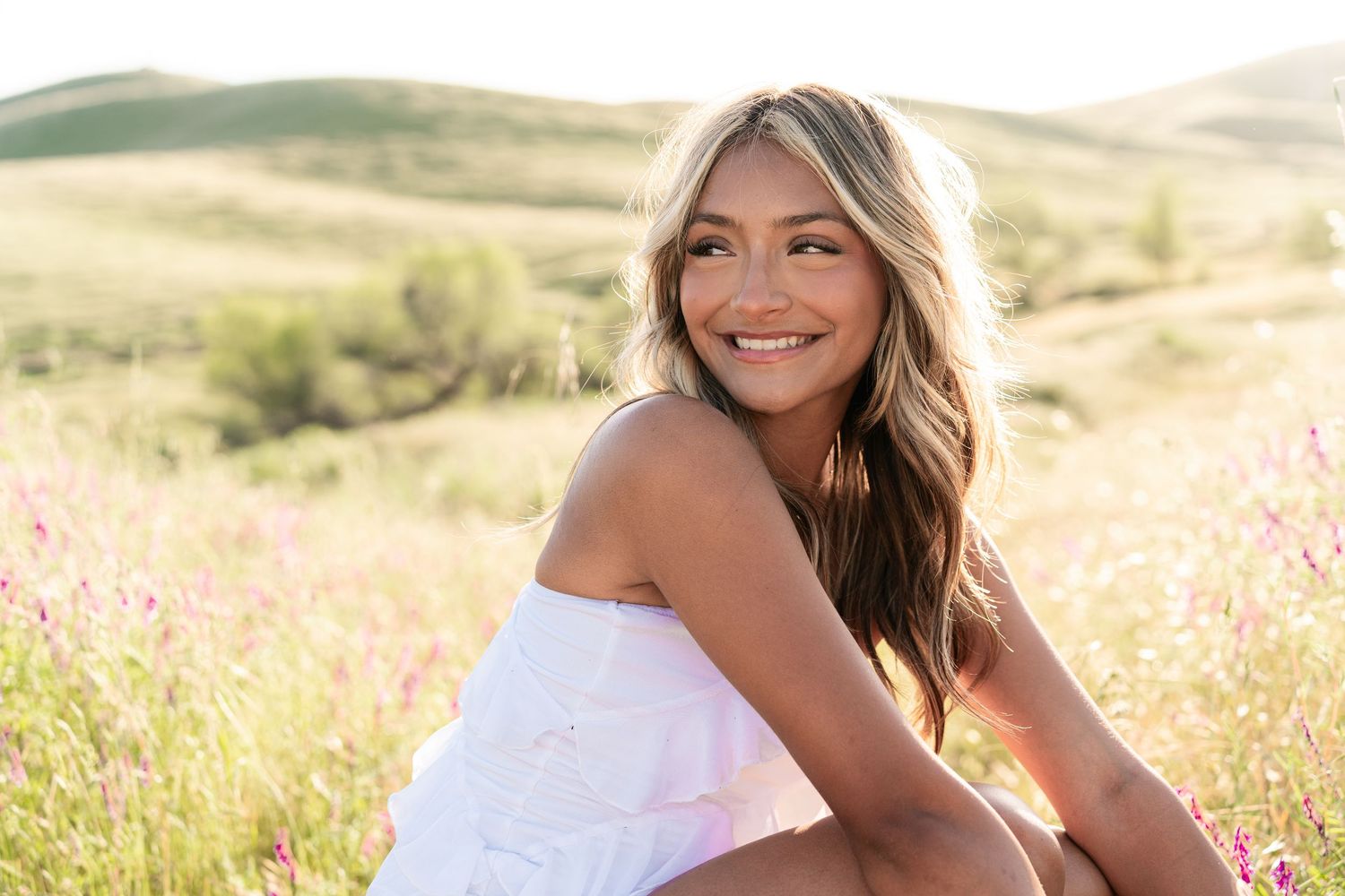 Candid outdoor photography in a meadow with pink wildflowers during golden hour.