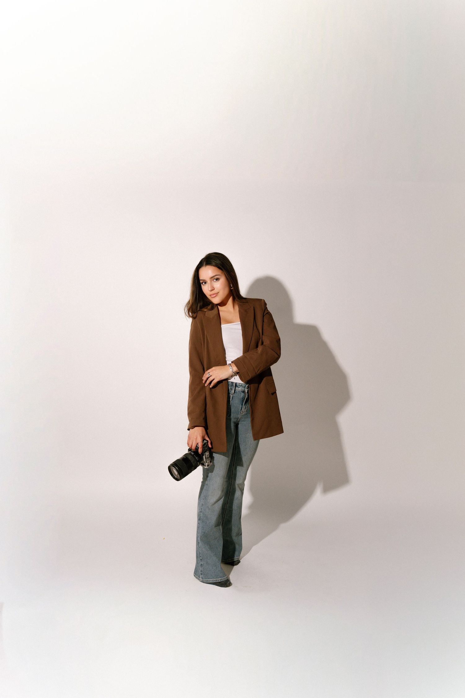 Model wearing oversized brown blazer and green pants poses in three different positions against white background.