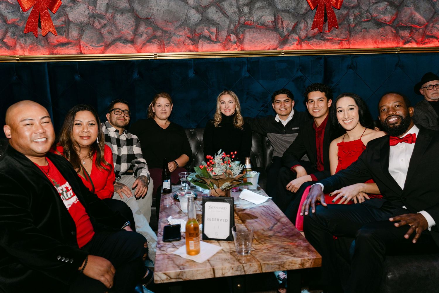 Red-themed party venue with guests mingling at tables during a social gathering.