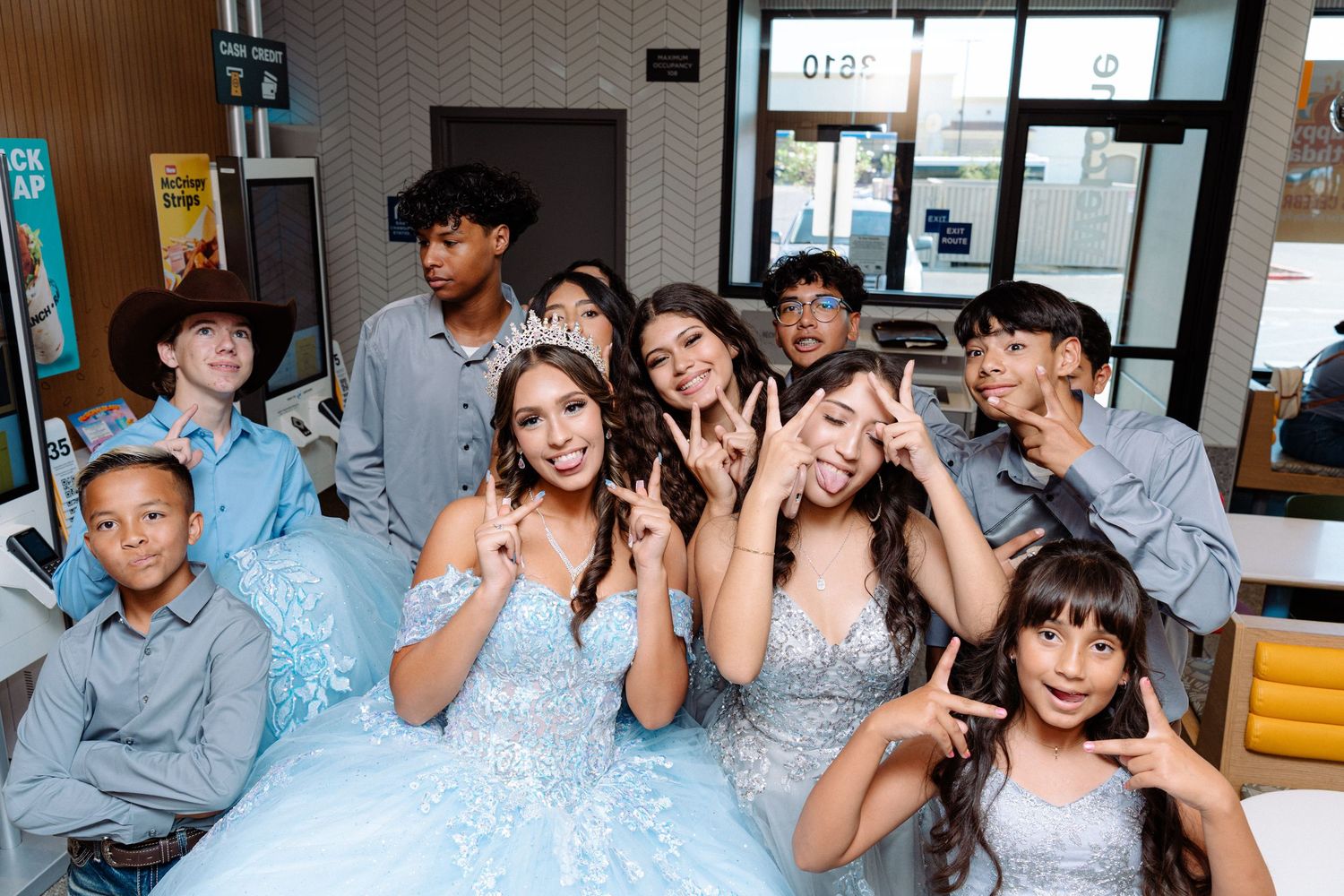A group of people in coordinated outfits pose together in an indoor setting.