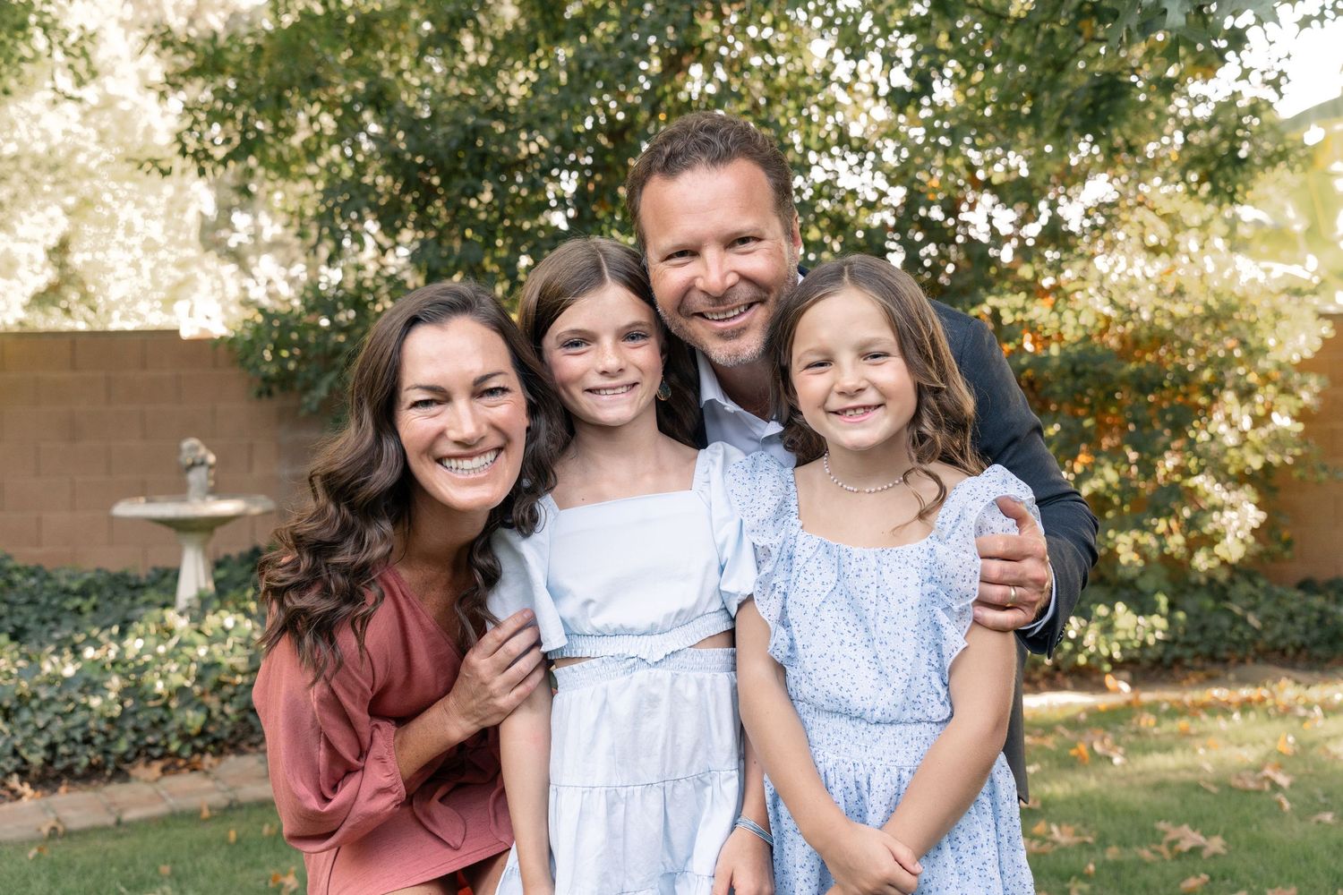 Family enjoying a candid outdoor photo session in a natural setting with warm lighting.