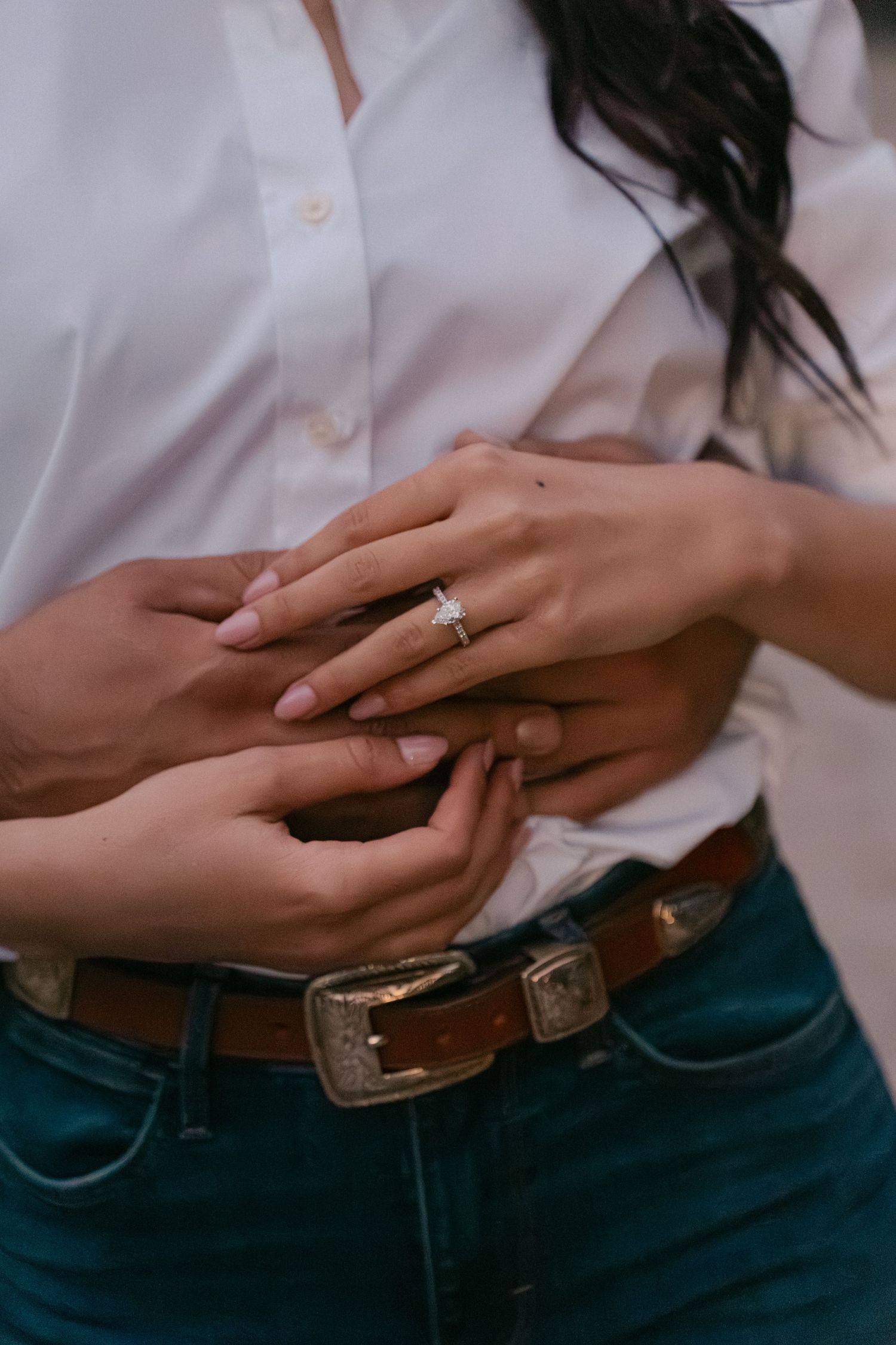 Close-up series of hands showing engagement ring on finger with white shirt and jeans outfit details.