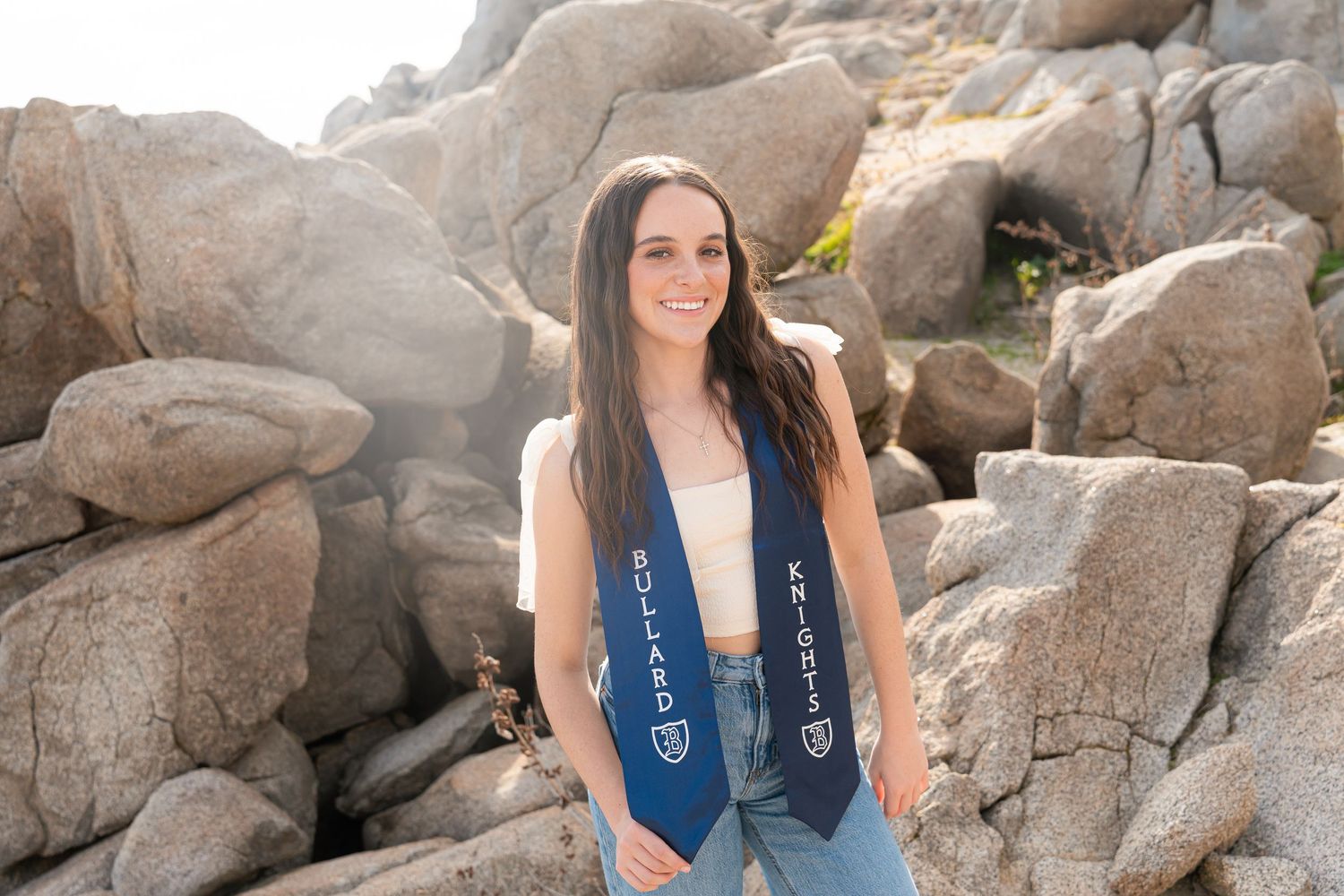 Scenic outdoor photoshoot among large desert boulders and rock formations in natural lighting.