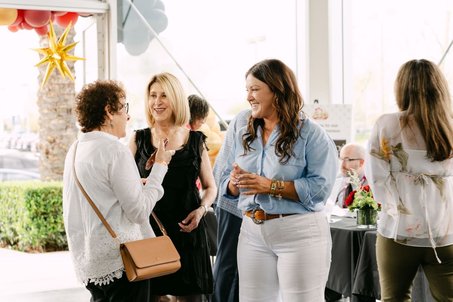 A group of people mingling and socializing at a professional networking event with drinks and conversation.
