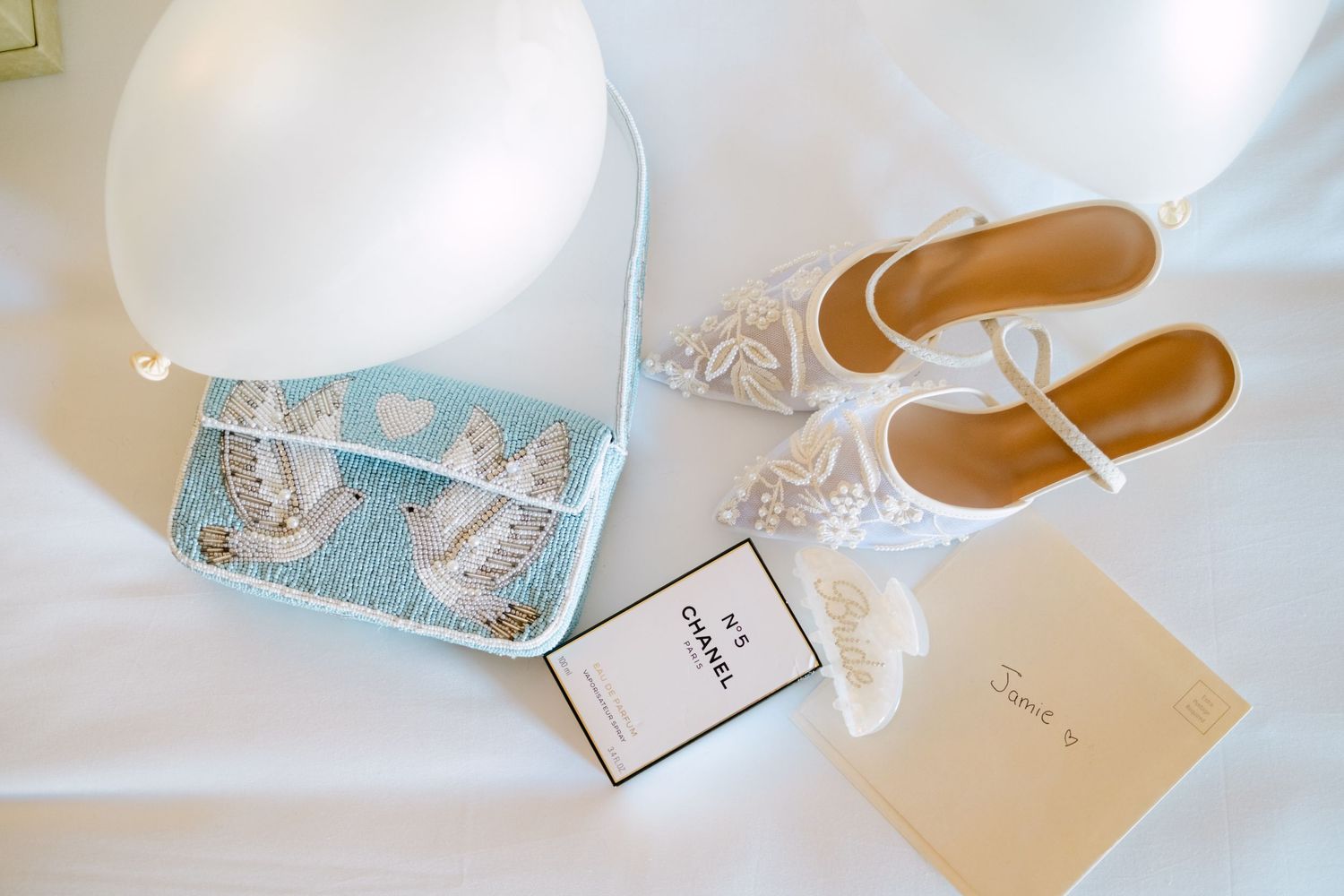 Flat lay arrangement of brown leather sandals and blue floral gift tags or cards on a white surface.