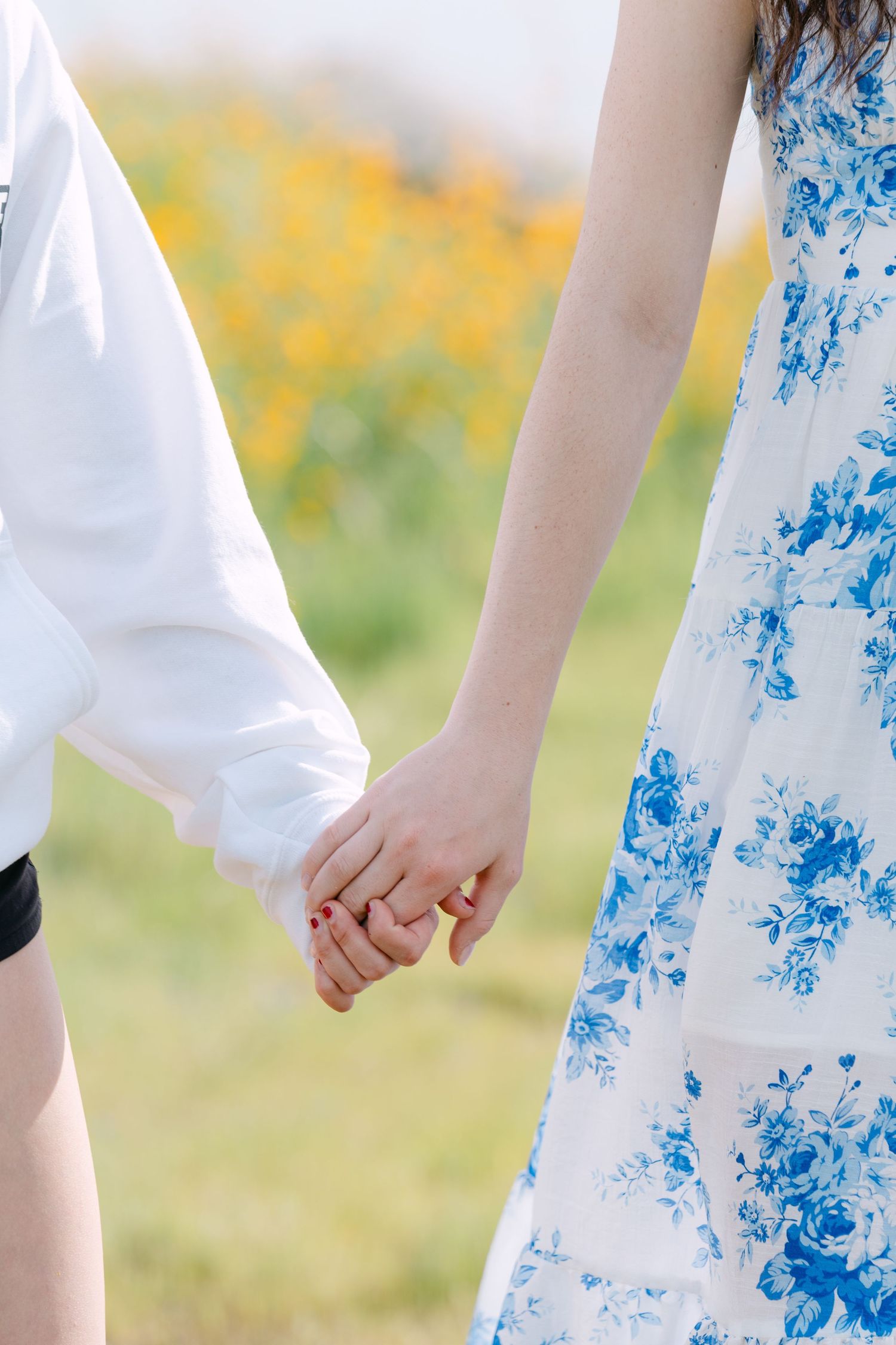 Detail shot of a blue and white floral dress against blooming wildflowers.