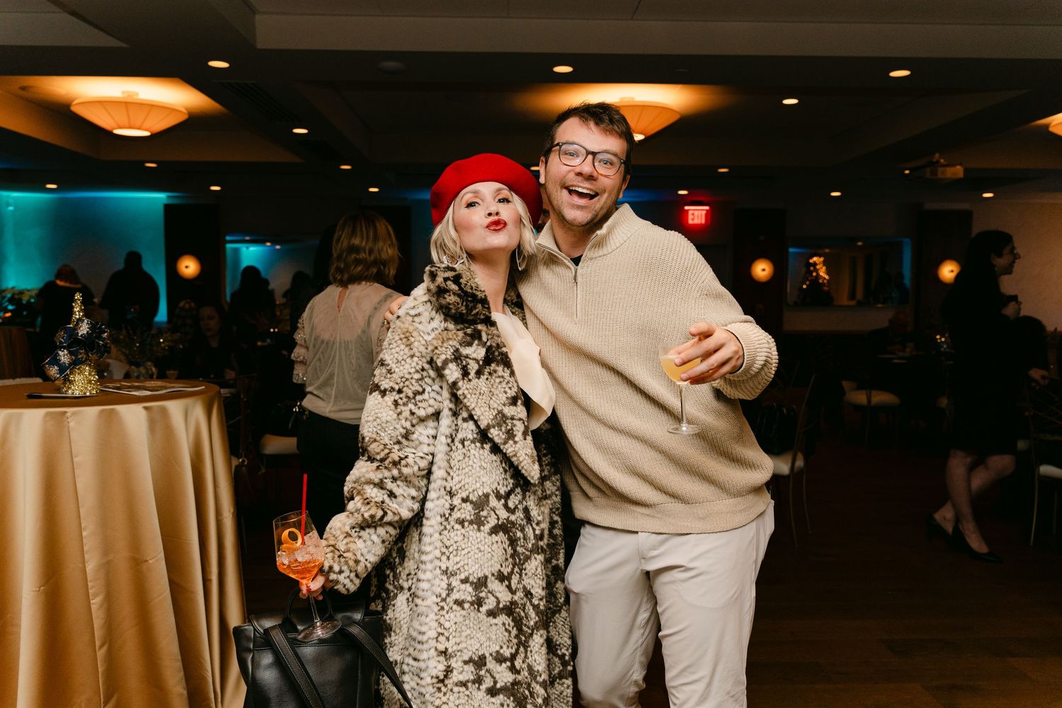 People dancing and celebrating at an evening event with warm ambient lighting.