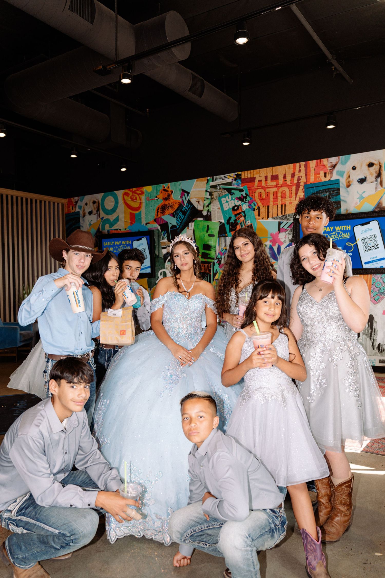 A celebratory group photo with people in matching gray and blue formal attire.