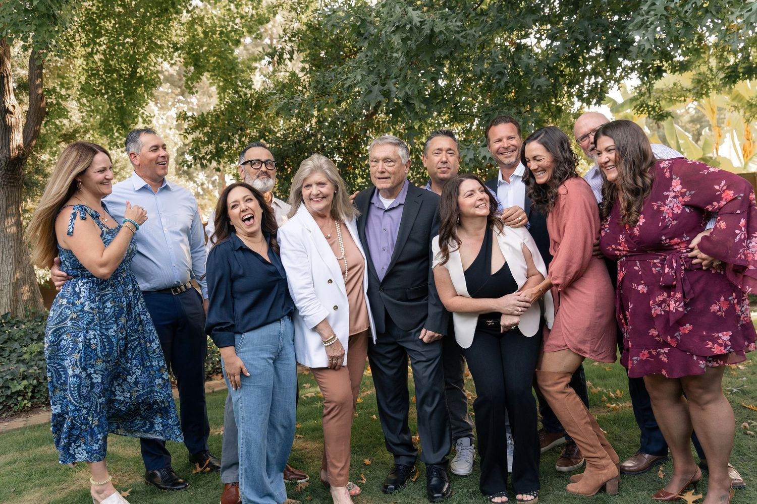 Casual outdoor group gathering with people in colorful attire against a natural backdrop.