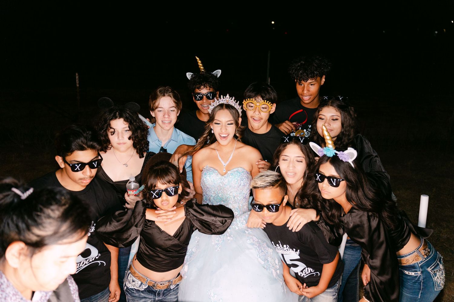 Friends gather around celebrating at an outdoor nighttime party.