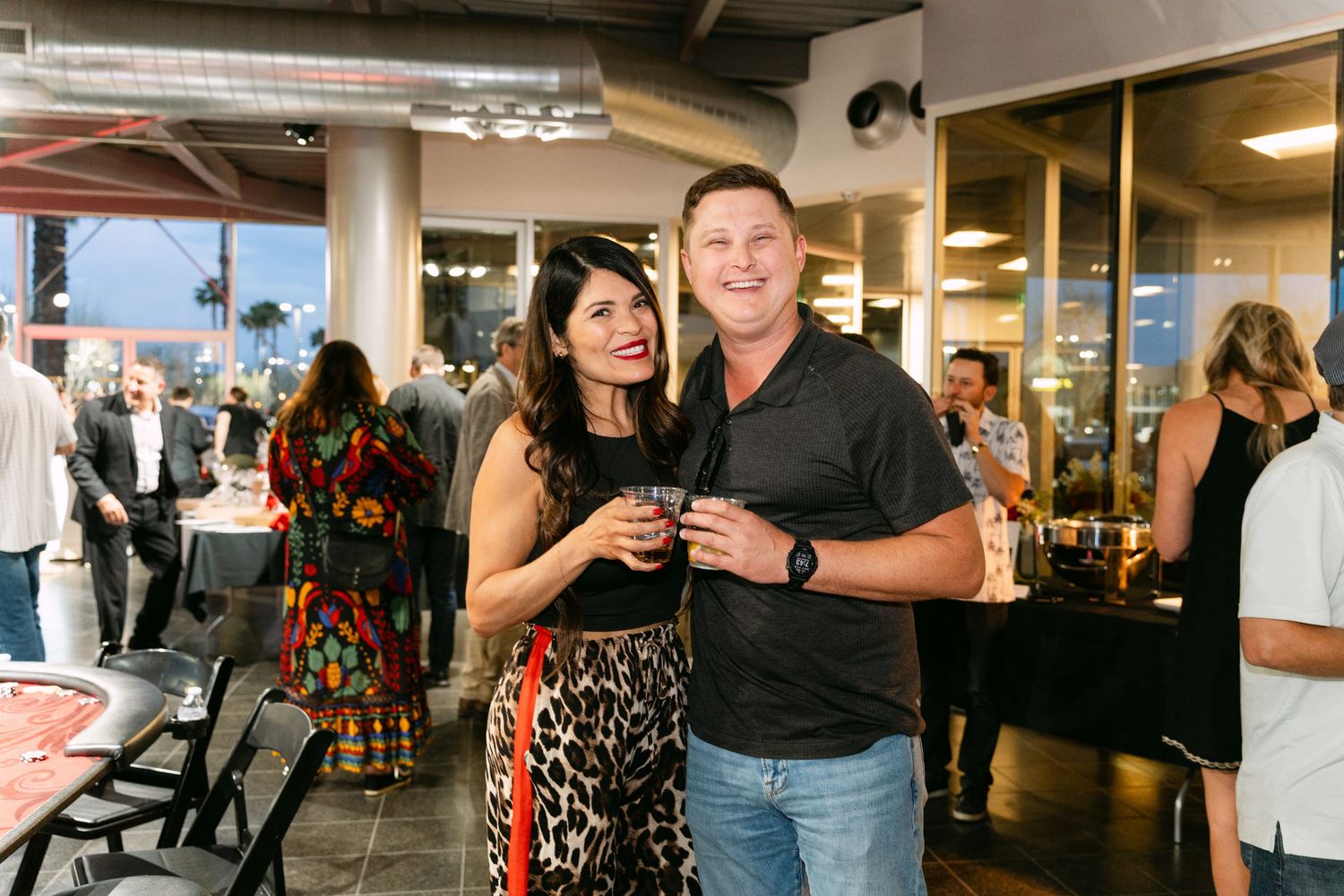 People networking and mingling at an indoor business or social event with festive decorations.