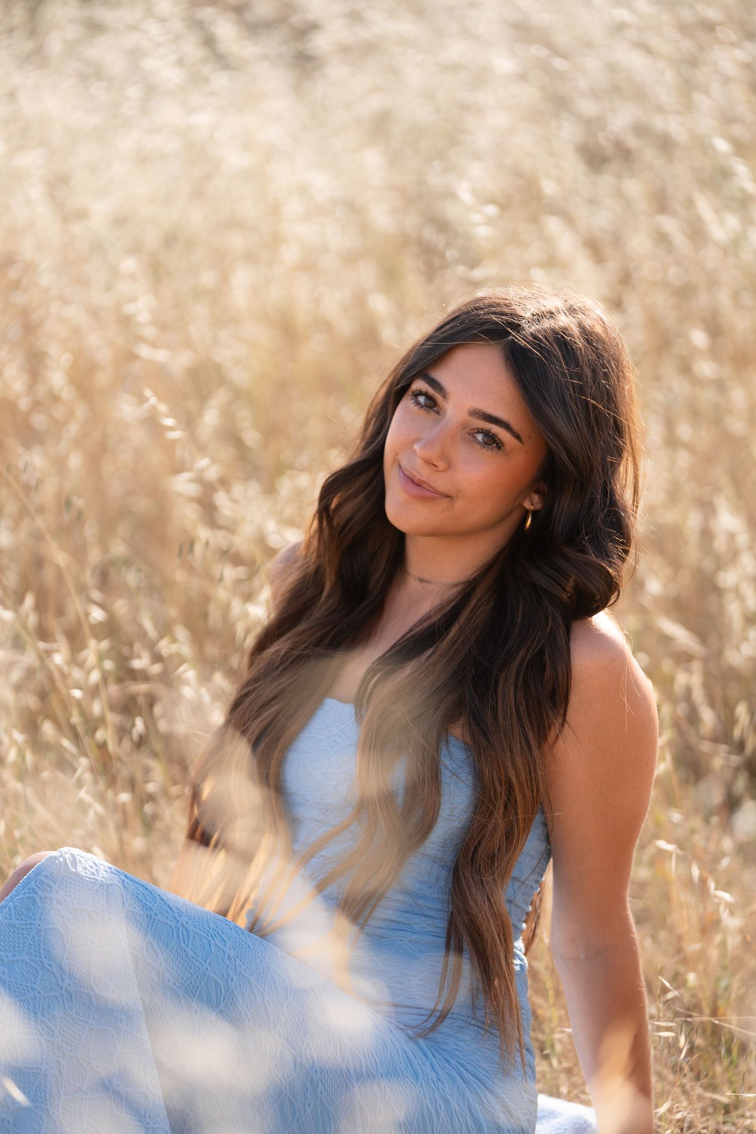 Portrait session in golden wheat field with soft natural lighting and dreamy atmosphere.