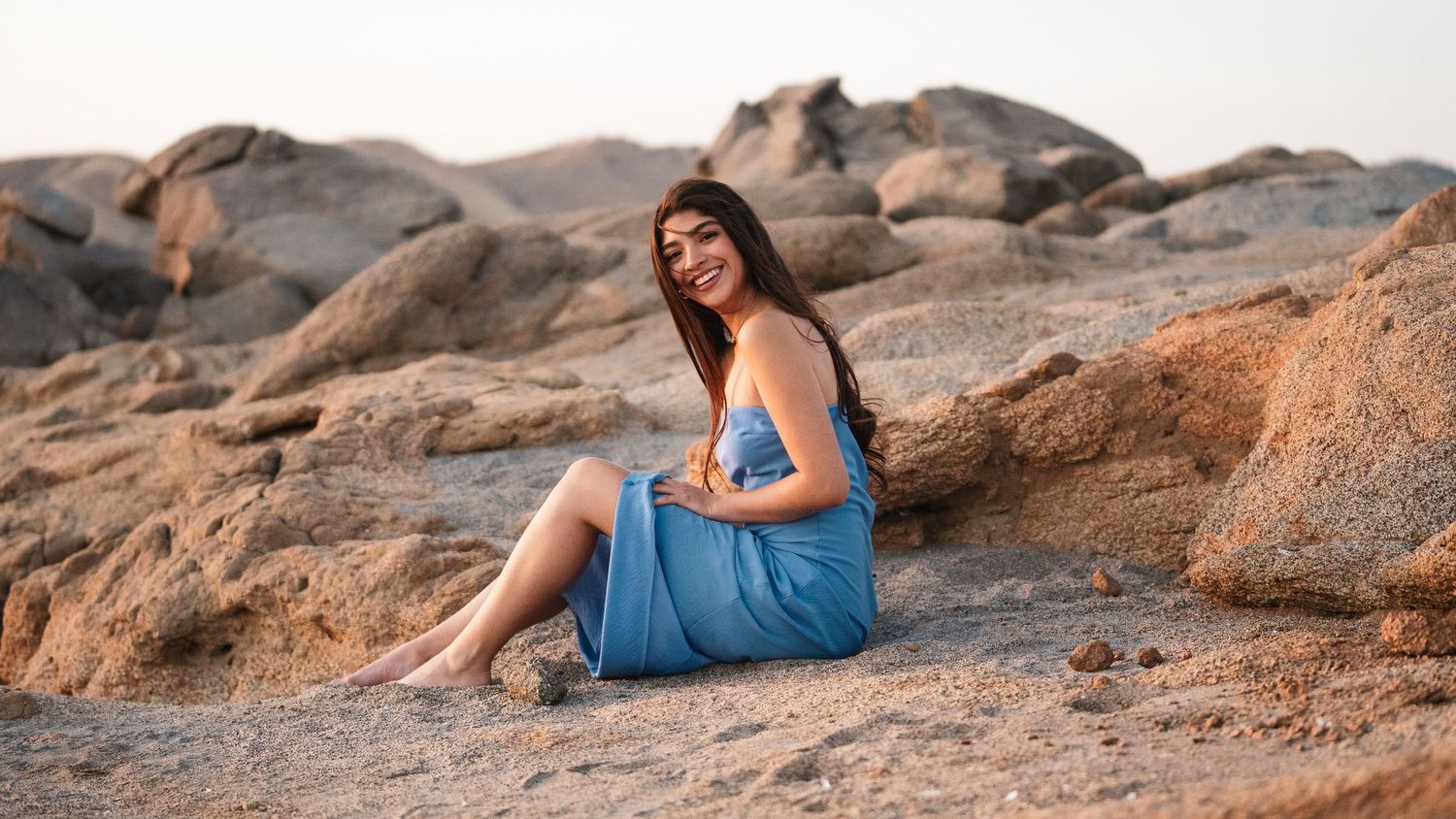 Artistic portrait session on rocky terrain during golden hour.
