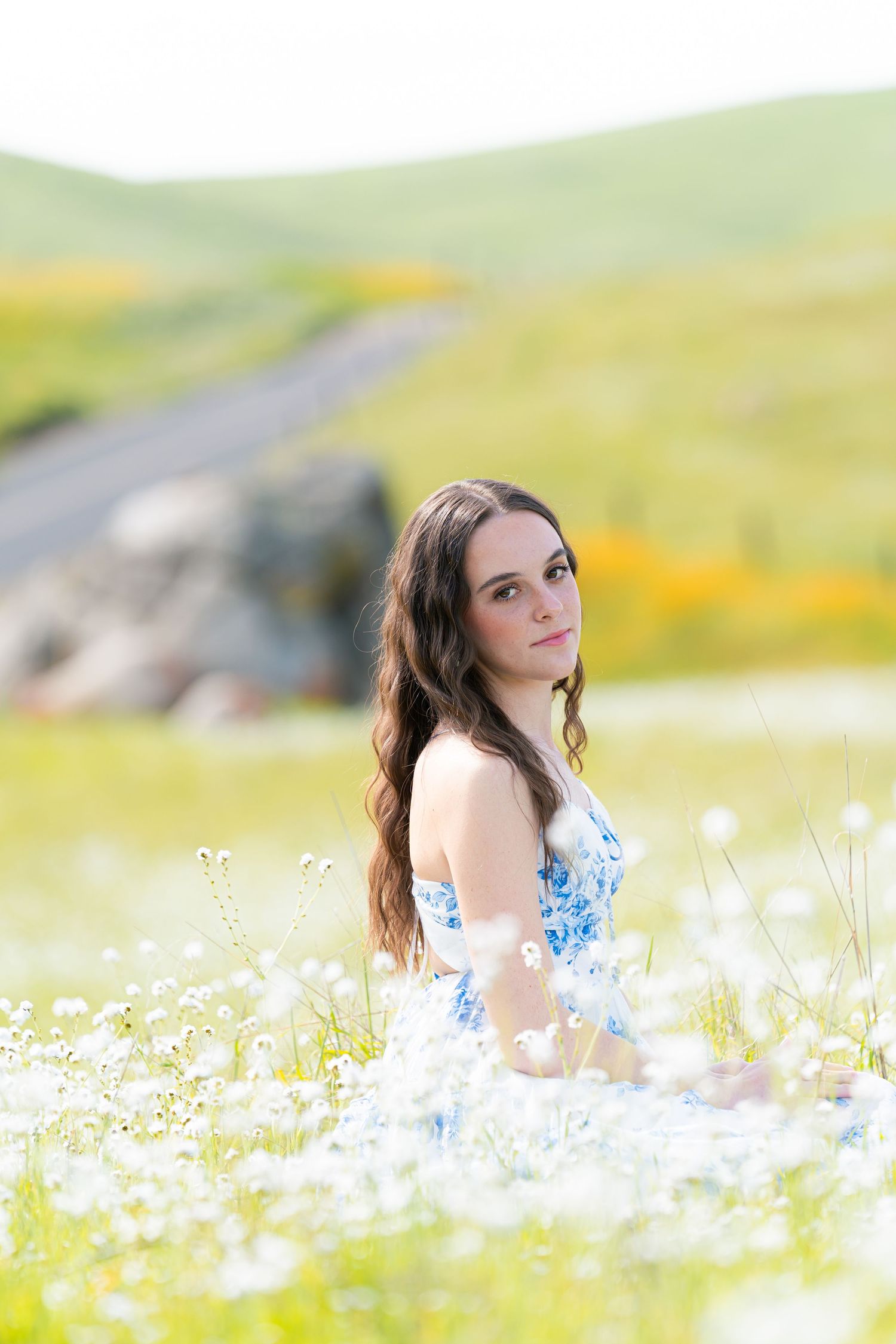 Dreamy portrait in a field of white daisies with soft natural lighting and blurred background.