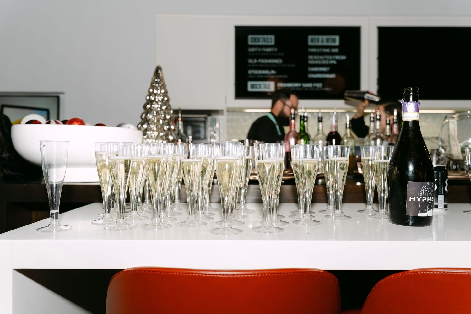 Row of elegant champagne glasses and wine bottles set up for a celebration event.