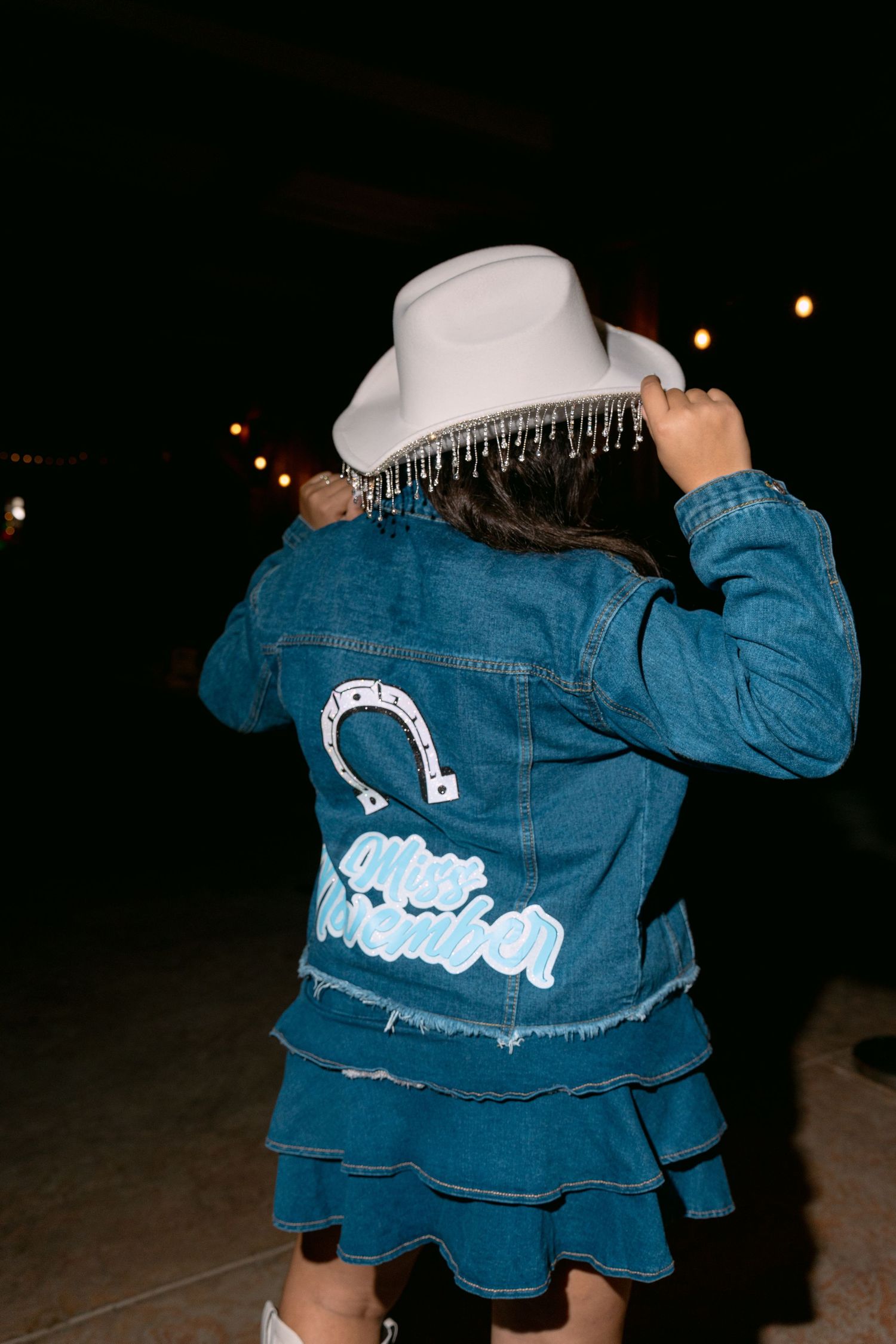 A series of photos showing a denim jacket with custom artwork on the back viewed from different angles.