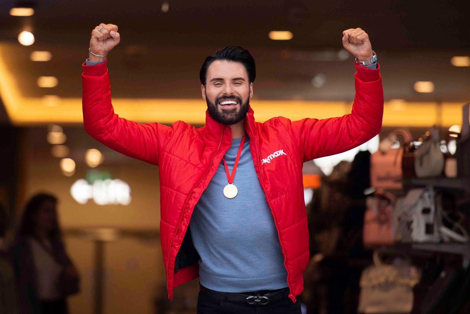 People in red jackets celebrating with arms raised in indoor setting. London Event Photographer