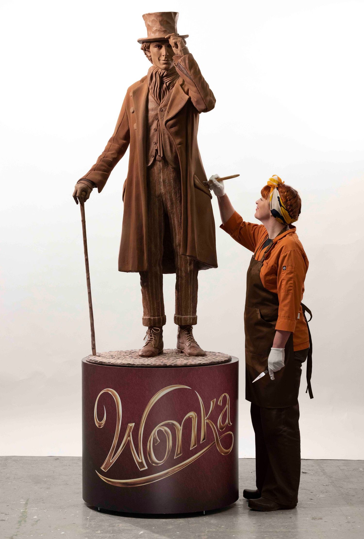 Life-size Willy Wonka statue being maintained by worker in costume. London Event Photographer