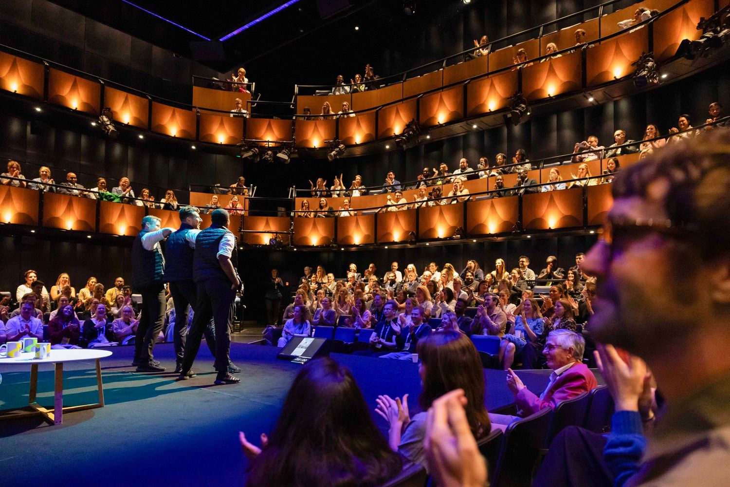 Large audience gathered in an illuminated auditorium during a professional conference or event. London Event Photographer