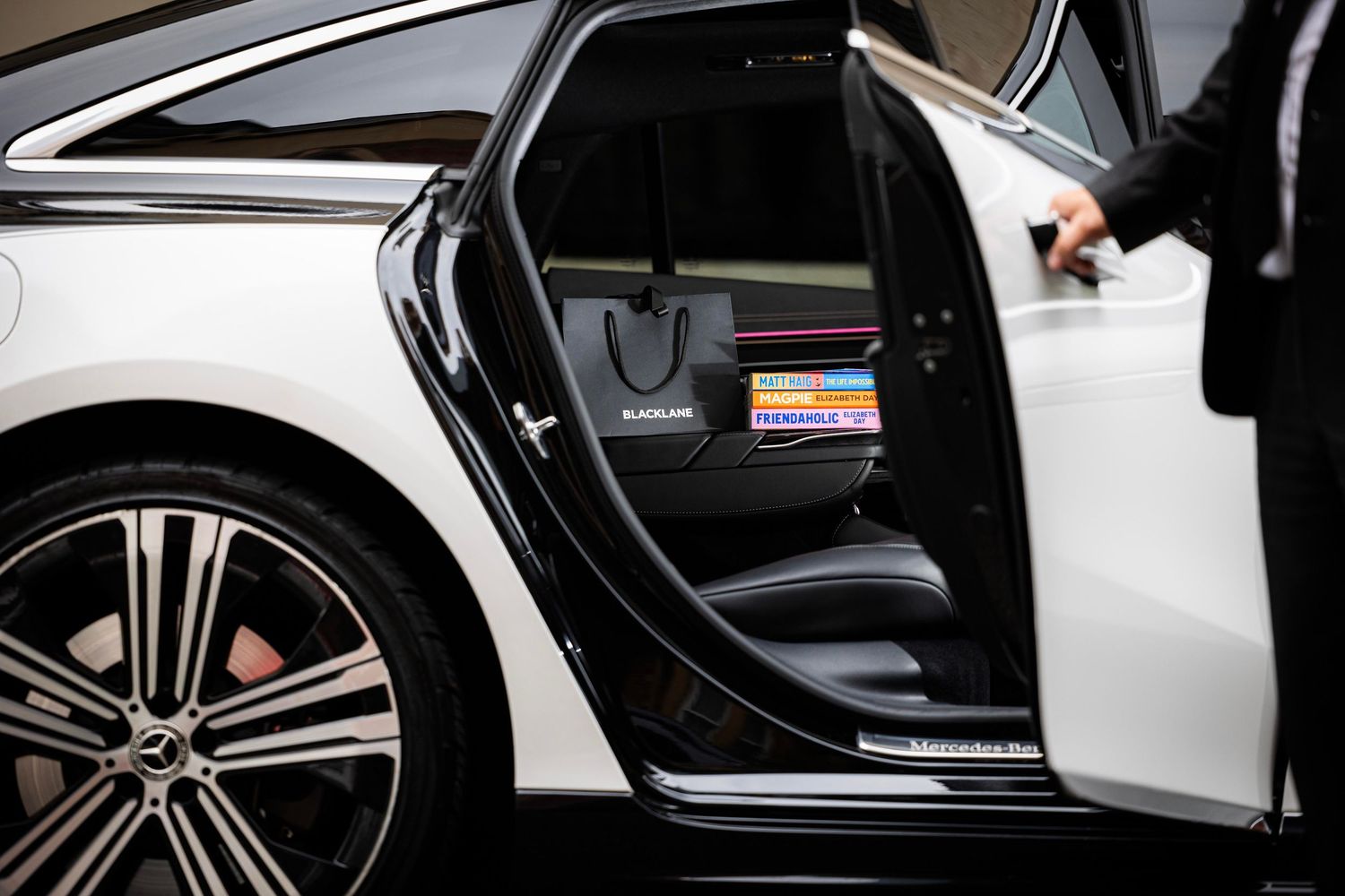 Luxury car interior details showing open door and leather seats in black and white. London Event Photographer