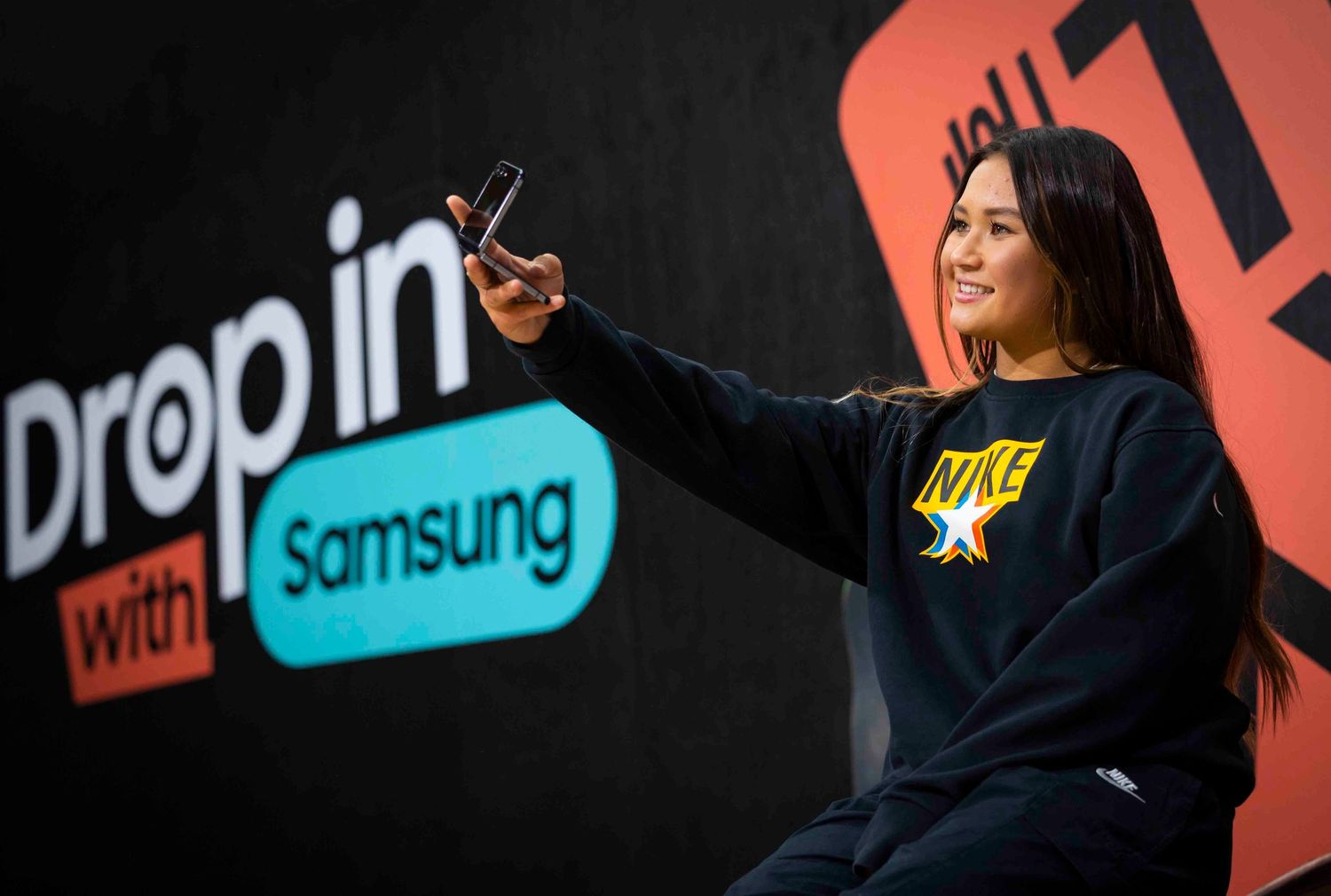 Person taking selfie at Samsung Drop In event with branded backdrop. London Event Photographer