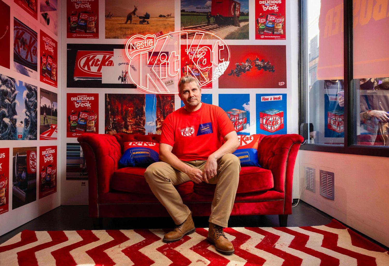 Red-themed room with chevron pattern rug and sports memorabilia displayed on walls. London Event Photographer