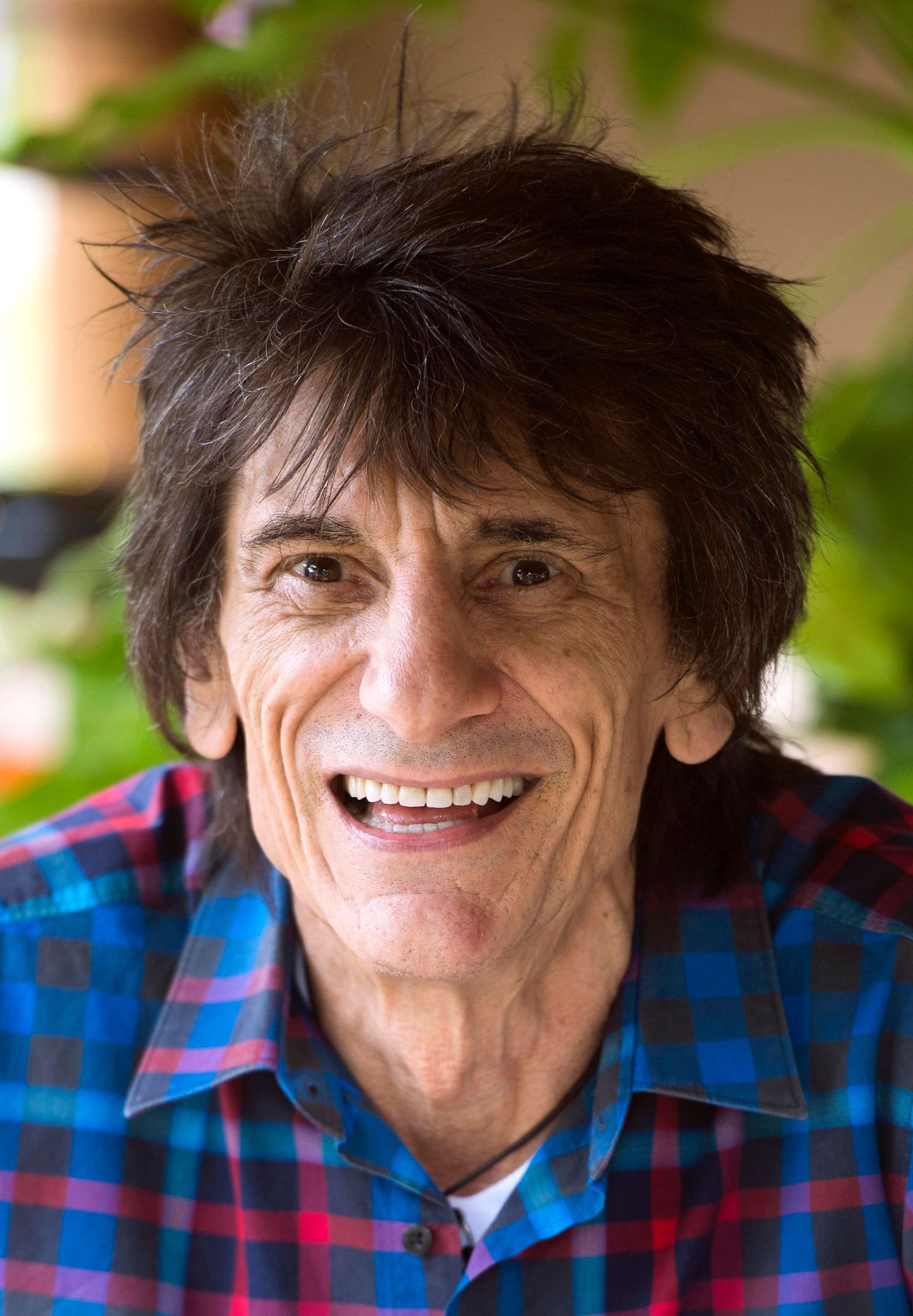 A series of expressive portraits showing someone in a blue and red plaid shirt against a blurred background. London Event Photographer