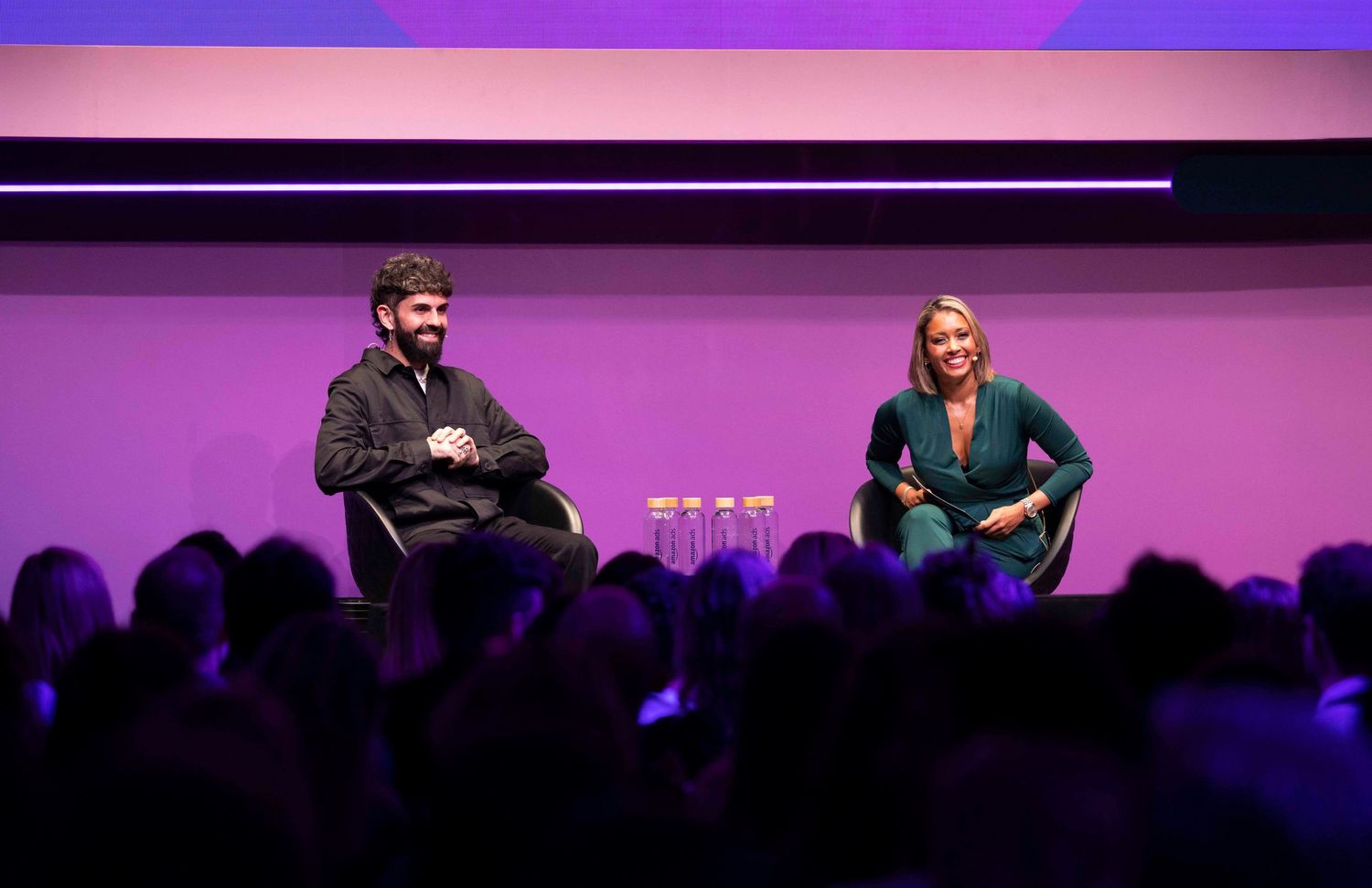 Stage presentation with purple lighting and audience silhouettes visible. London Event Photographer