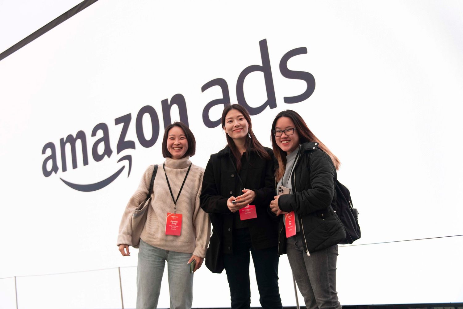 Business professionals networking at an Amazon AWS conference with company branding visible in the background. London Event Photographer