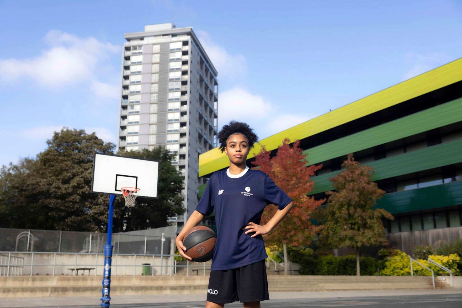 Athletic shots of someone playing basketball outdoors with apartment buildings in the background. London Event Photographer