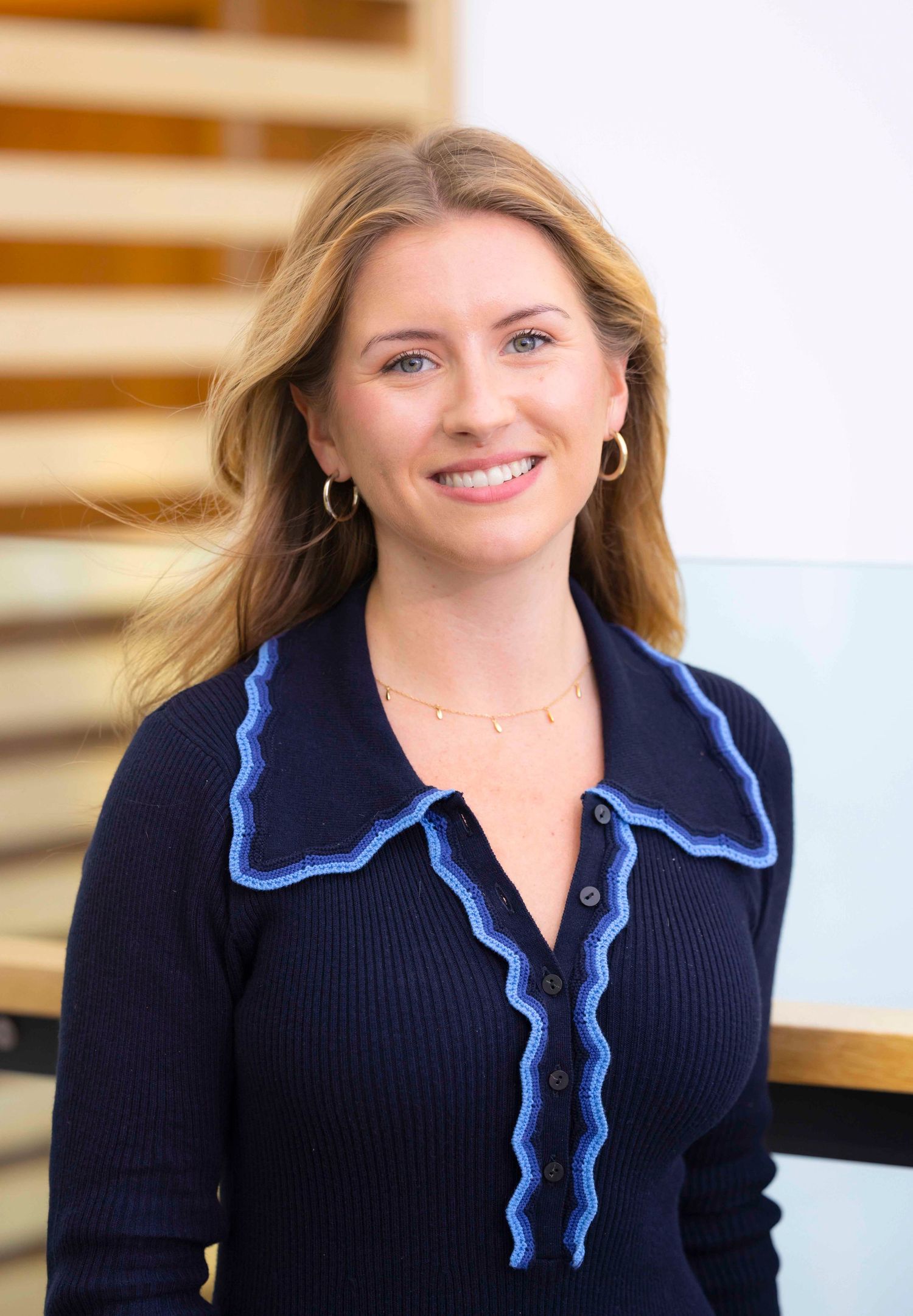 Professional wearing navy top with blue trim in office environment. London Event Photographer