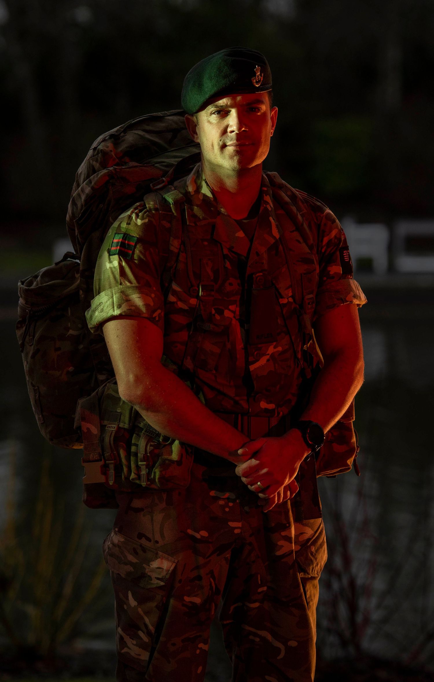 Person in camouflage gear photographed in dramatic lighting outdoors. London Event Photographer