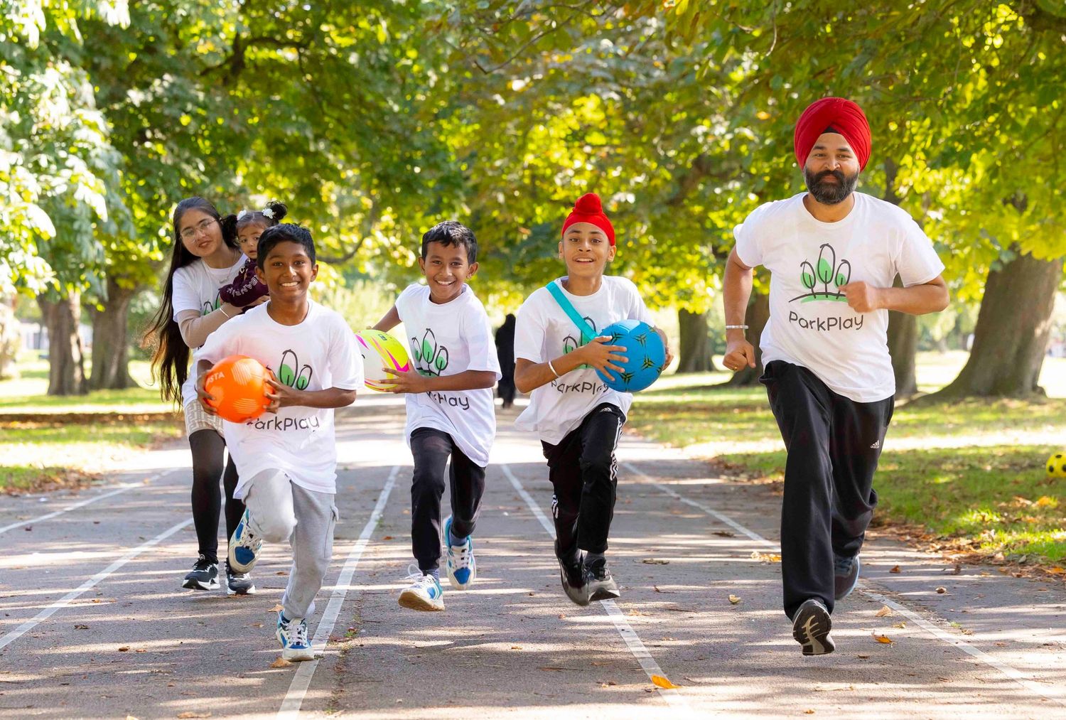 A group of runners exercising together on a tree-lined path during an outdoor fitness activity. London Event Photographer