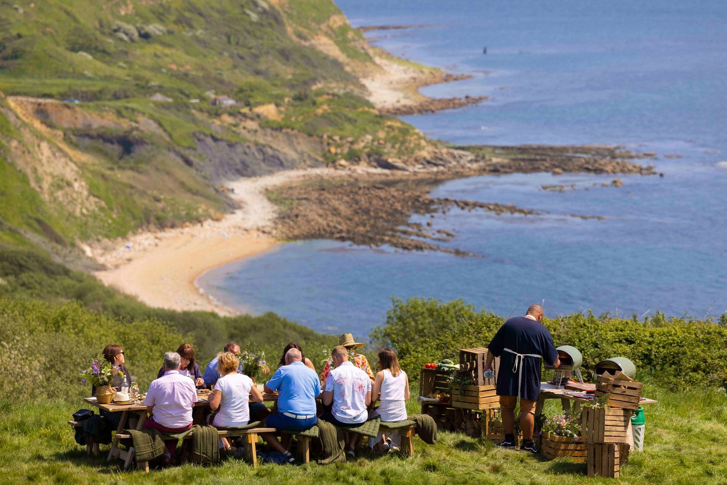 Coastal landscape with chairs set up for outdoor event overlooking dramatic cliffs and ocean. London Event Photographer