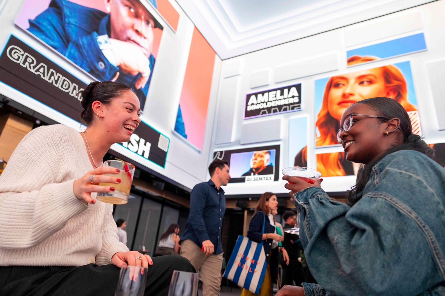 People engaged in animated conversation at a business networking event with displays in background. London Event Photographer