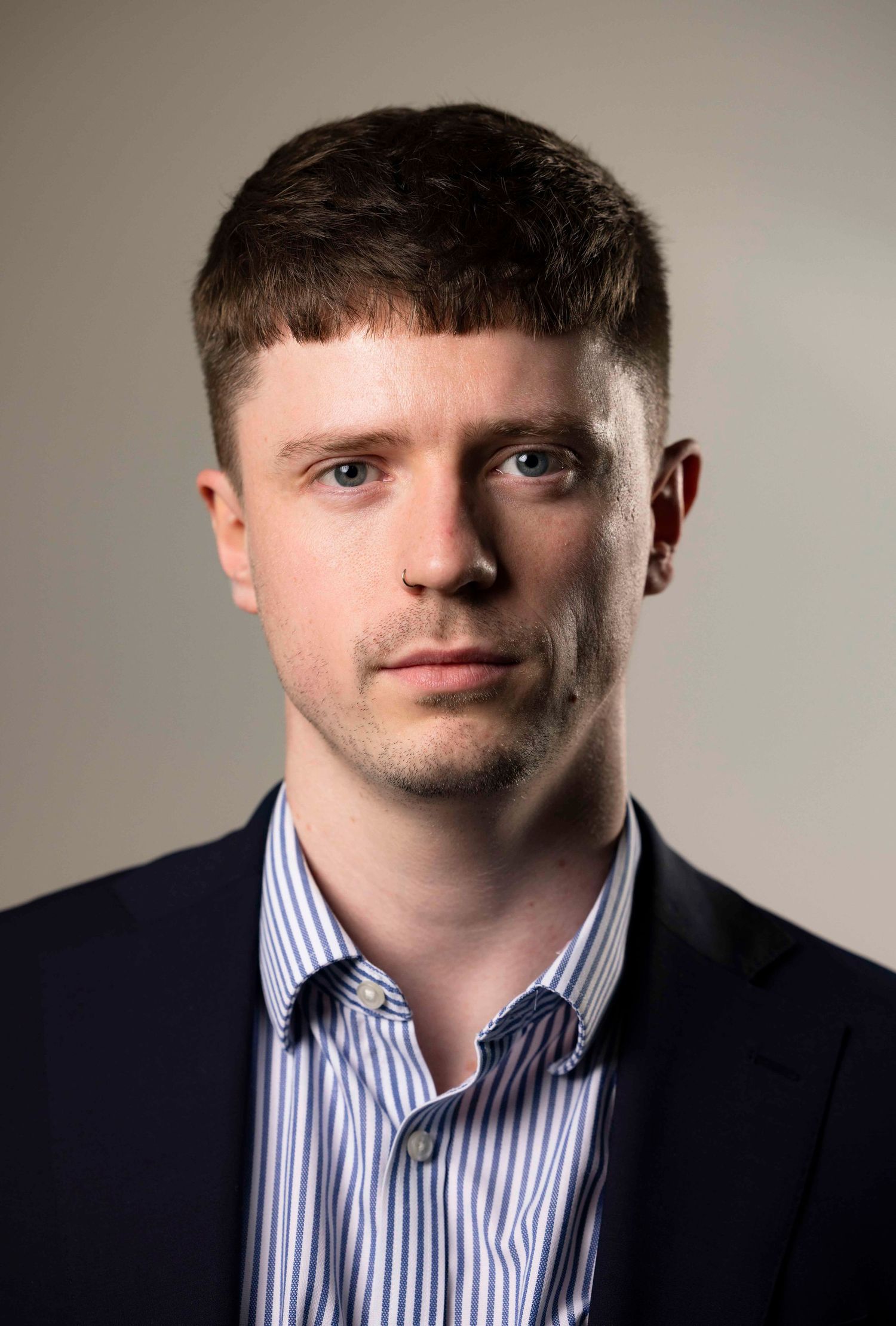 Professional headshot series in business attire against neutral grey background in London office. London Event Photographer