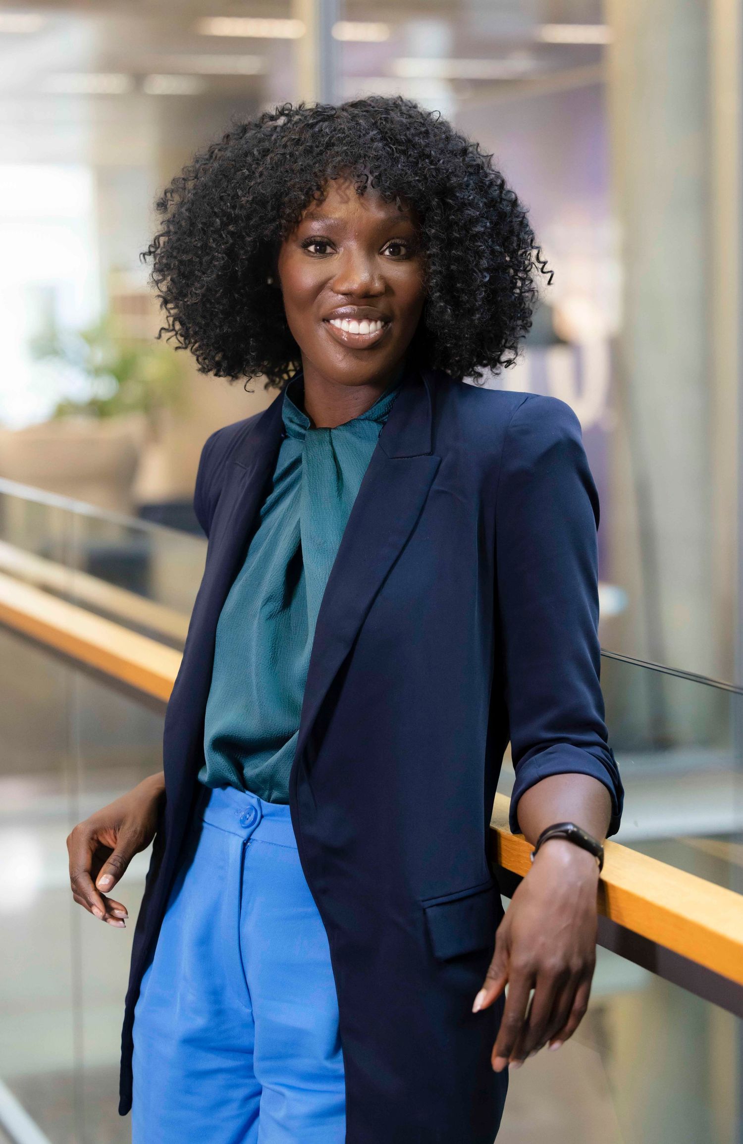 Professional wearing navy blazer and teal blouse with blue pants in london office setting. London Event Photographer