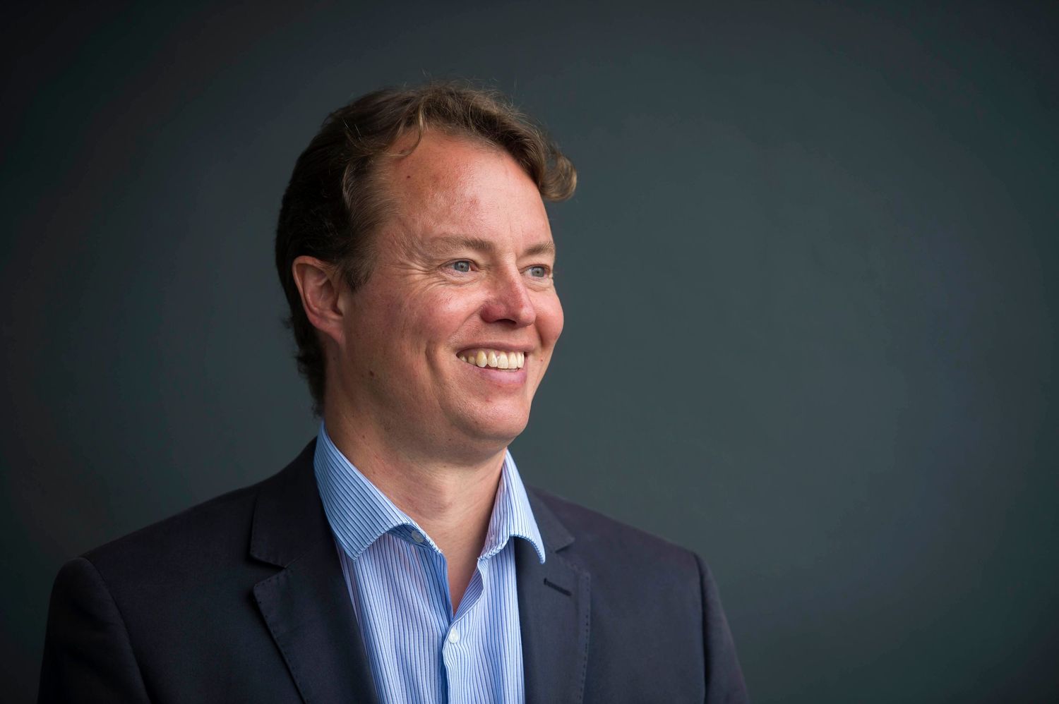 Professional headshots of someone in a business suit against a dark background. London Event Photographer