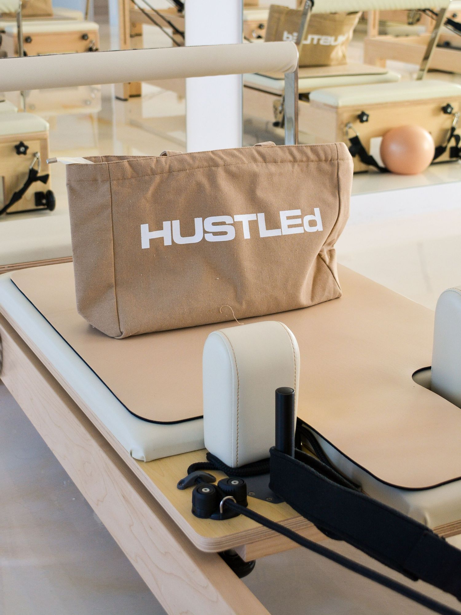 Close-up sequence showing the installation process of a Hustled brand sign on a light-colored surface.