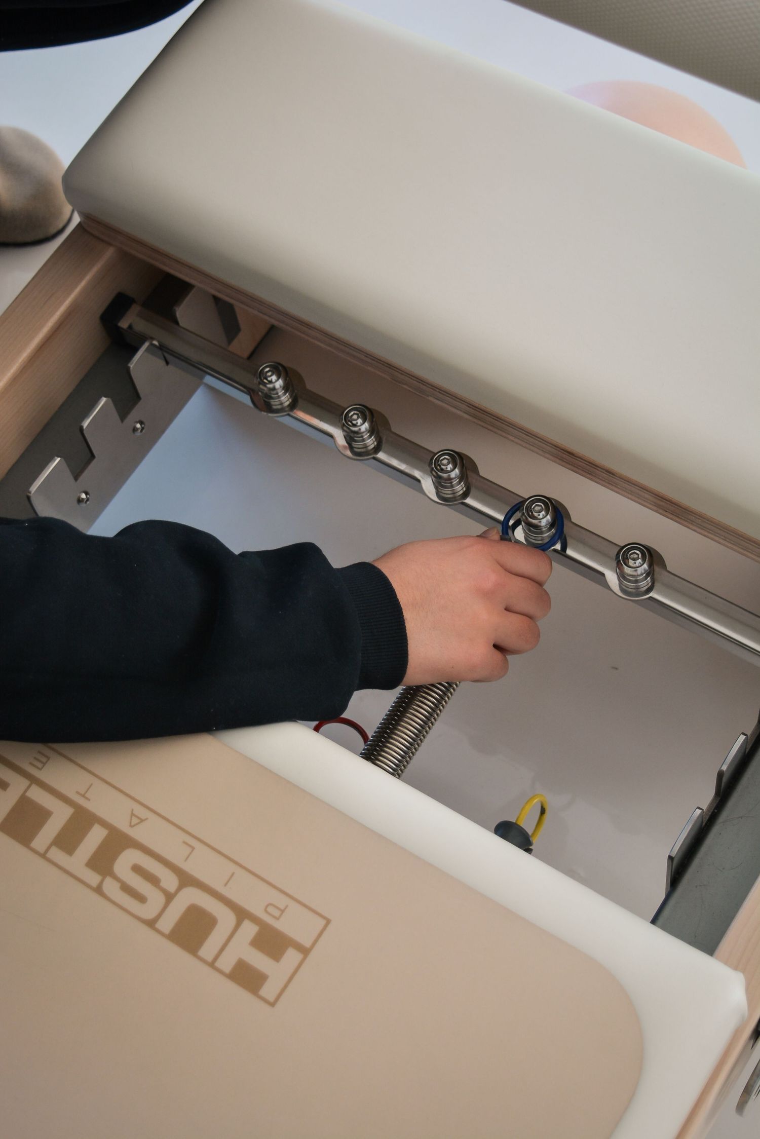 Hand adjusting metal clips on a white surface showing installation or maintenance process.