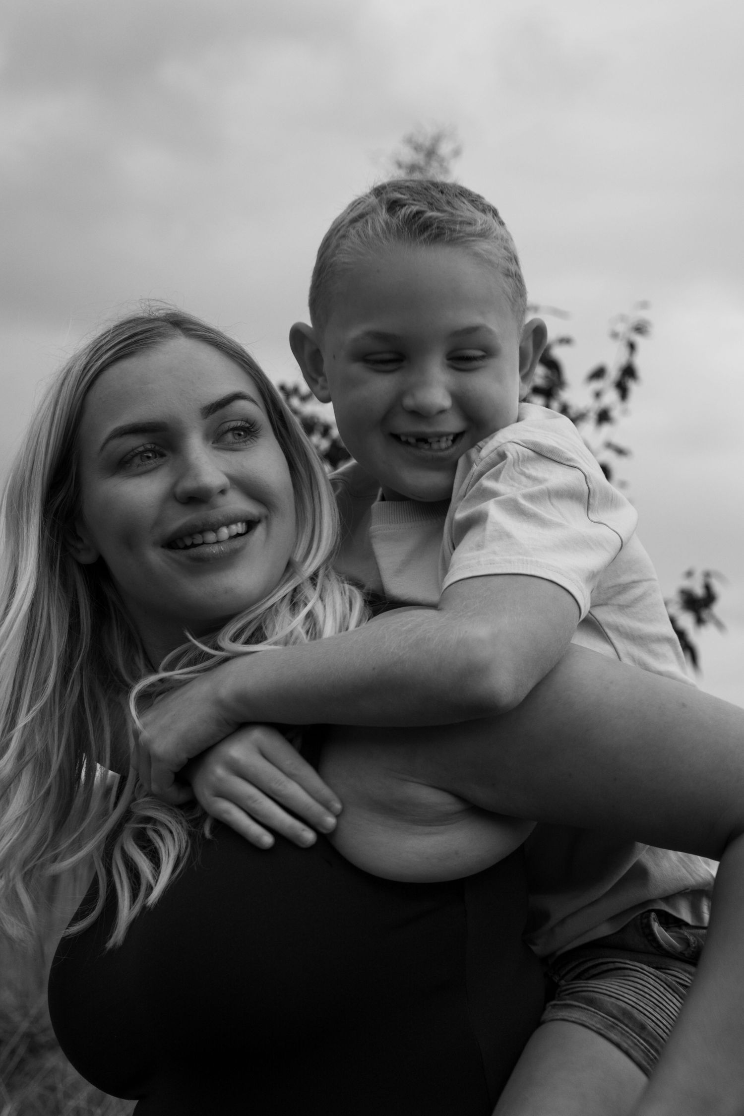 A black and white photo series showing joyful candid moments of playful embraces and laughter.