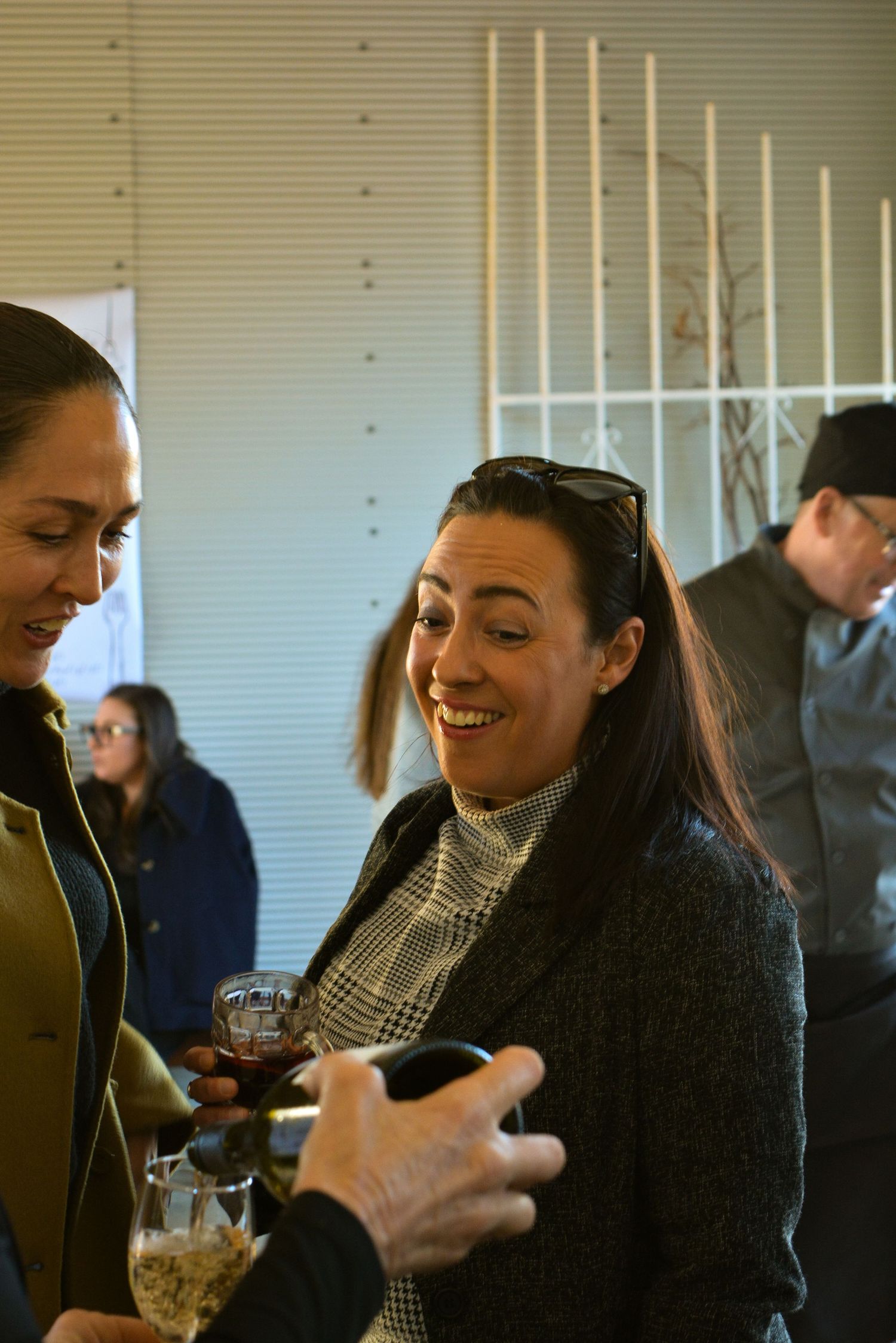 People socializing and enjoying drinks at an indoor gathering.