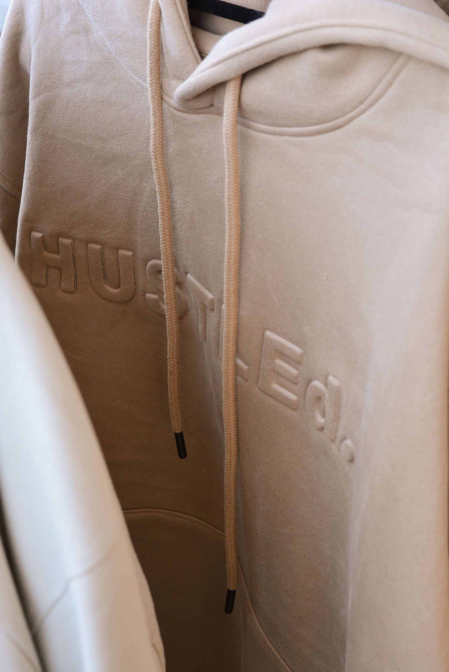 Close-up of embossed logo details on white fabric or textile material.