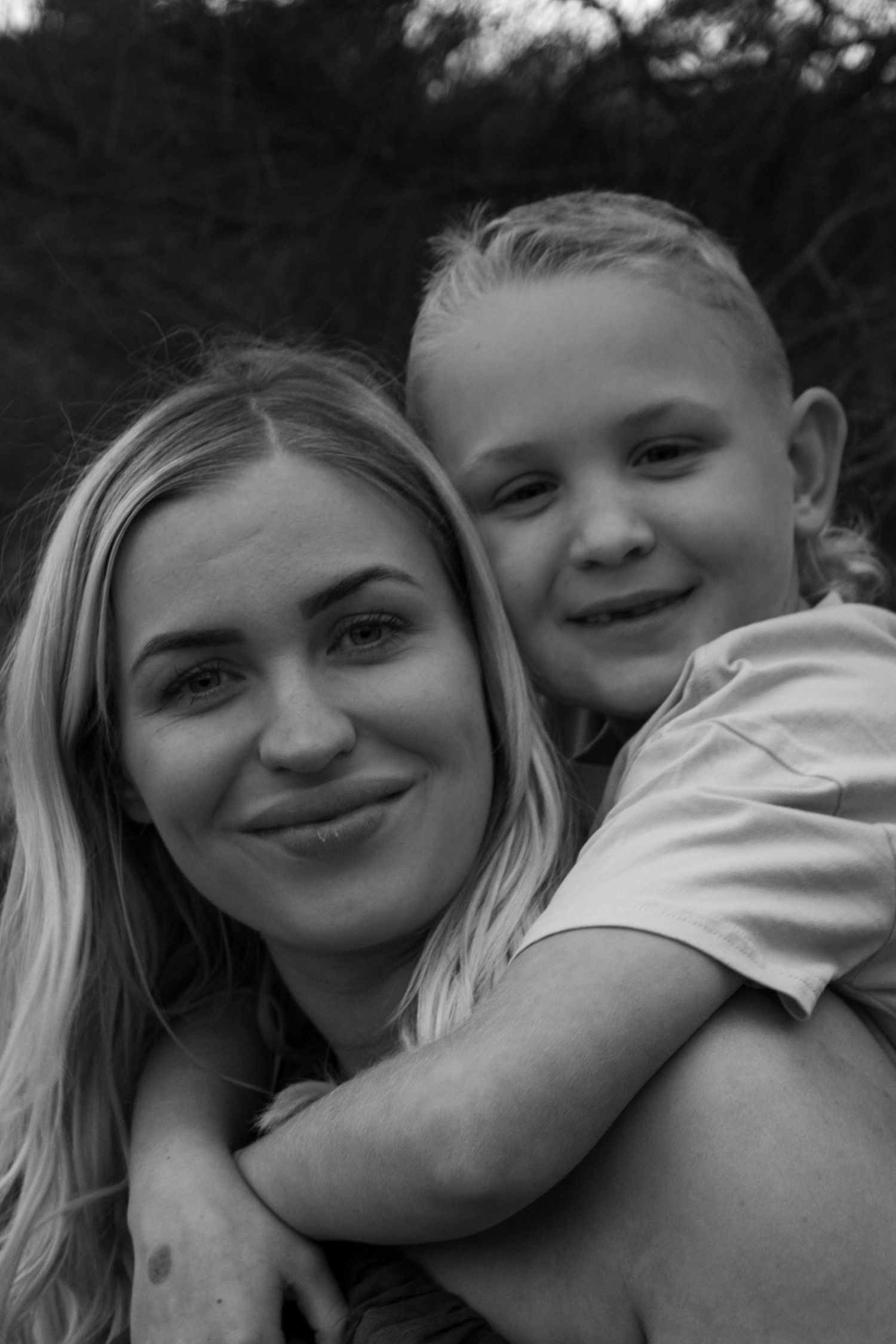 A series of four black and white photos showing tender moments between a parent and child in an embrace.