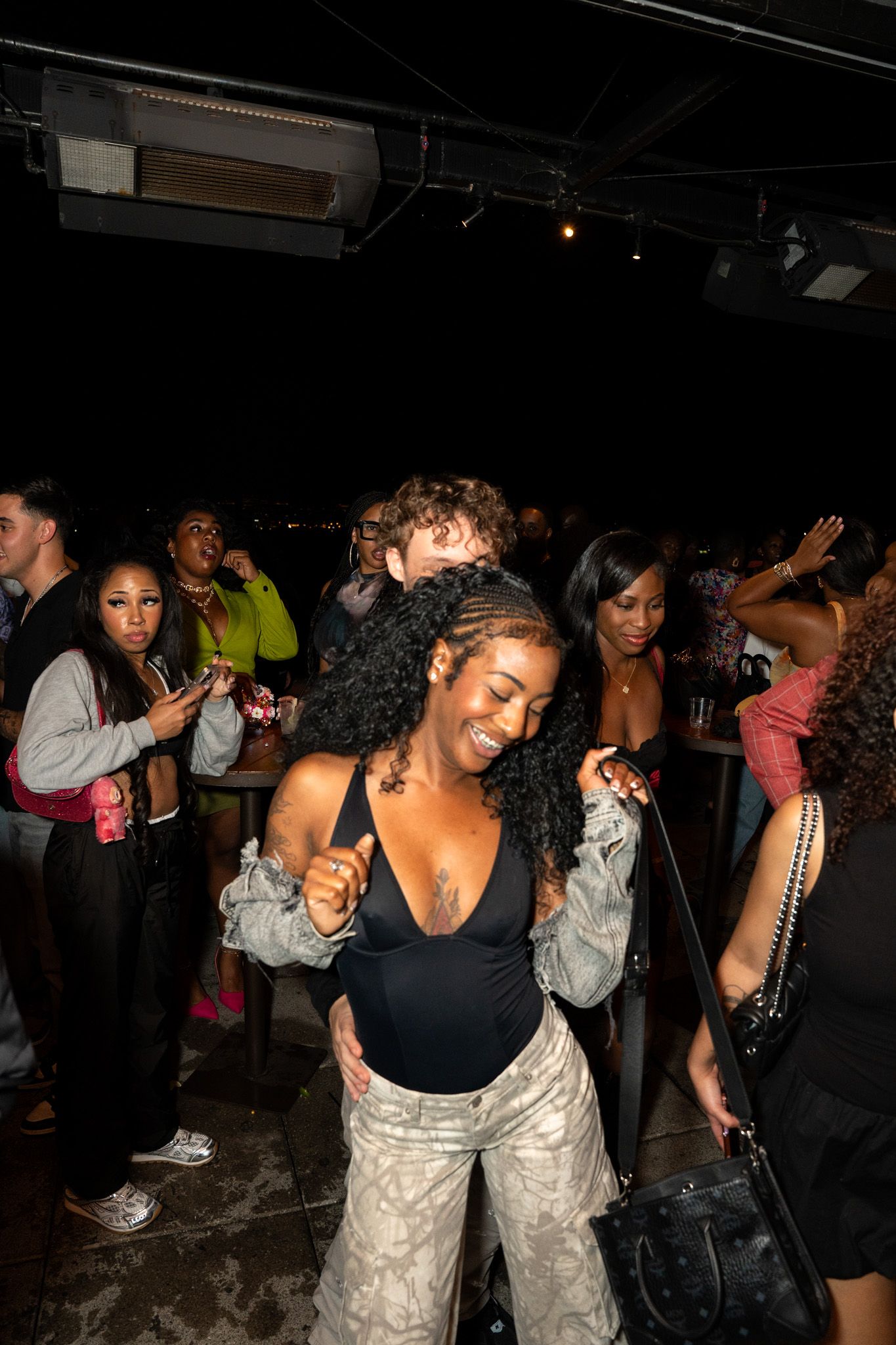 Energetic crowd dancing and having fun at a dark nightclub.